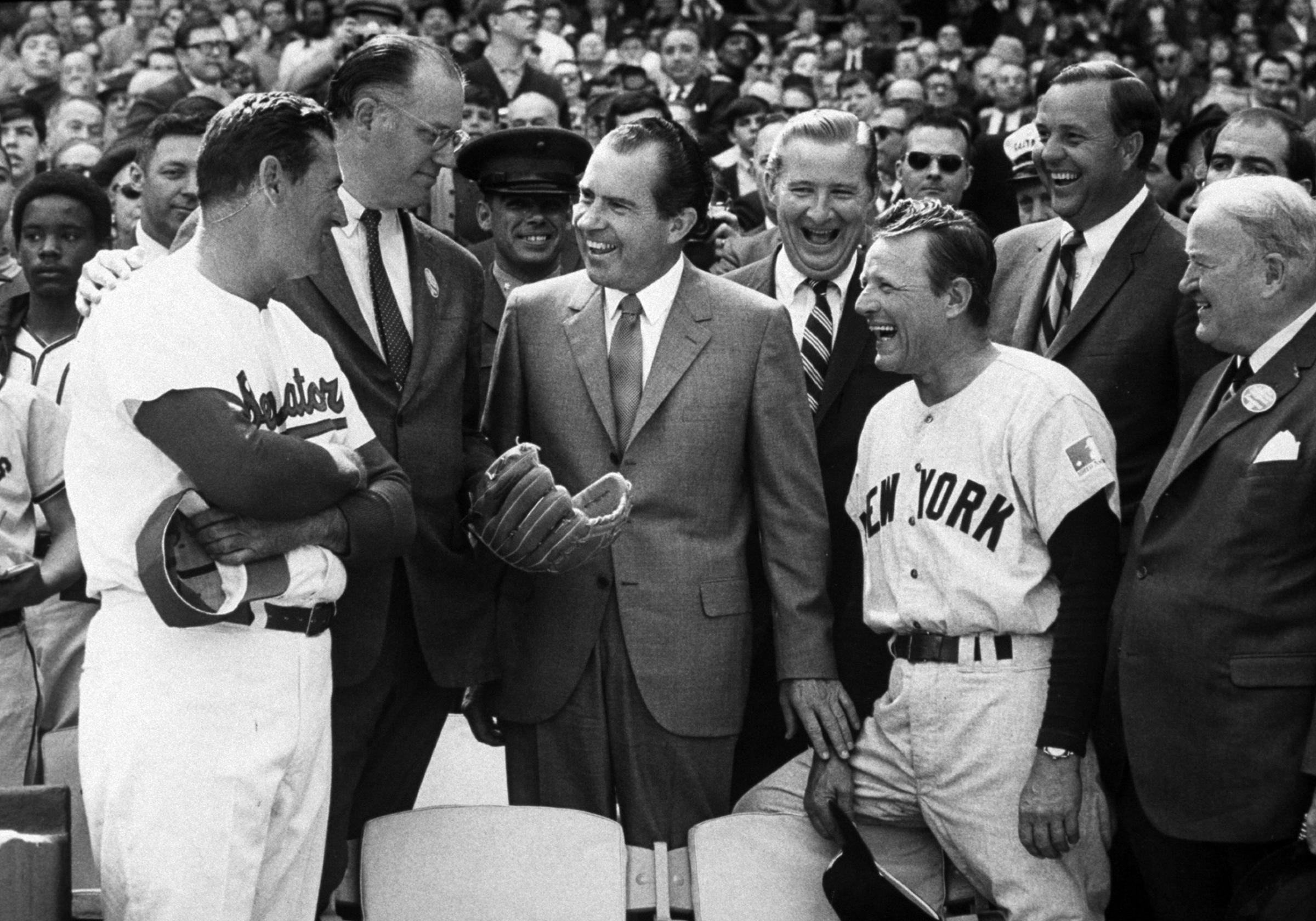 President Richard Nixon throws out the first pitch as manager Ted Williams of the Washington Senators, the MLB Commisioner Bowie Kuhn and manager Ralph Houk of the New York Yankees look on before opening day on April 7, 1969 at RFK Stadium in Washington, D.C.