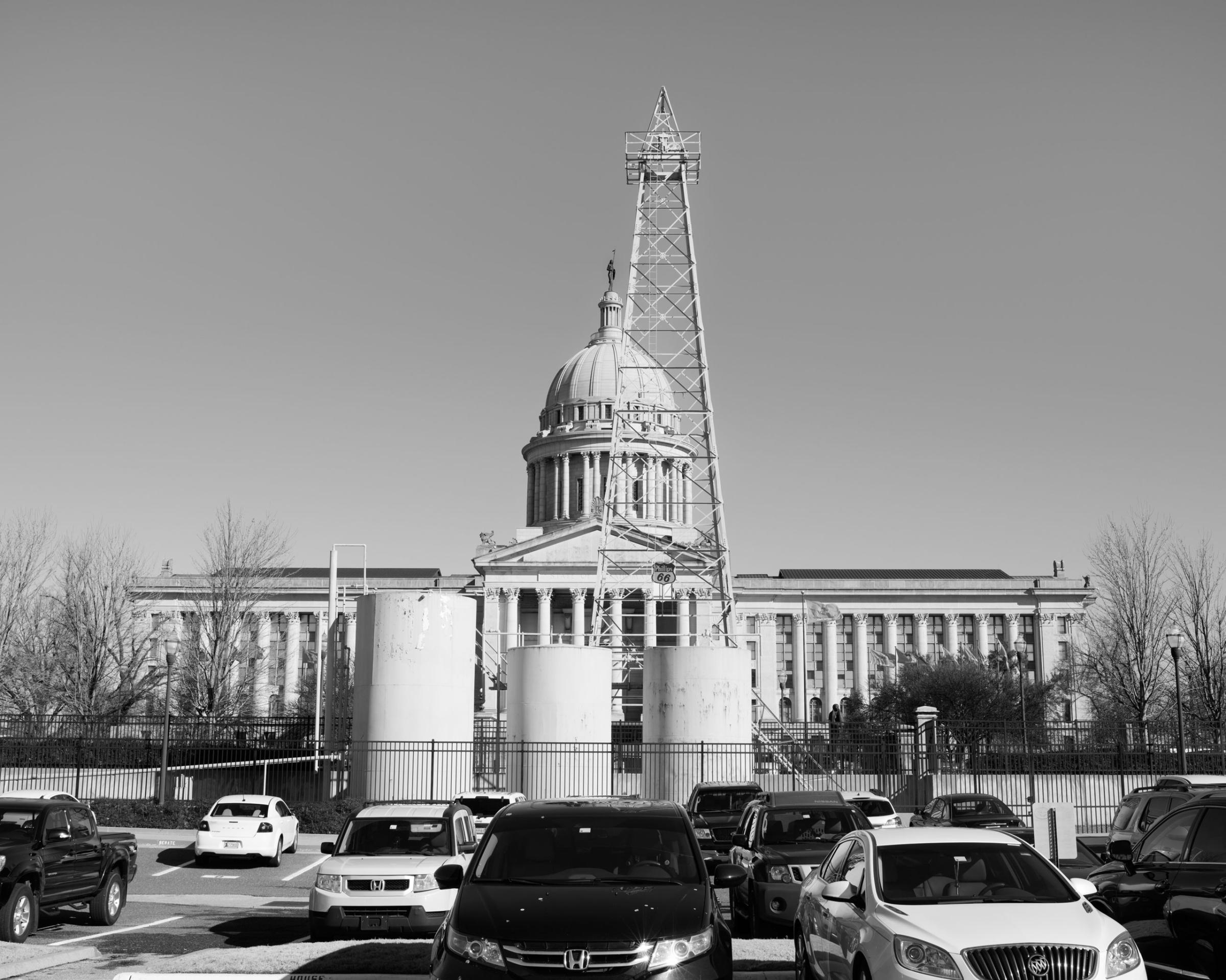 An oil rig stands in front of the Oklahoma State Capitol building, Oklahoma City, OK