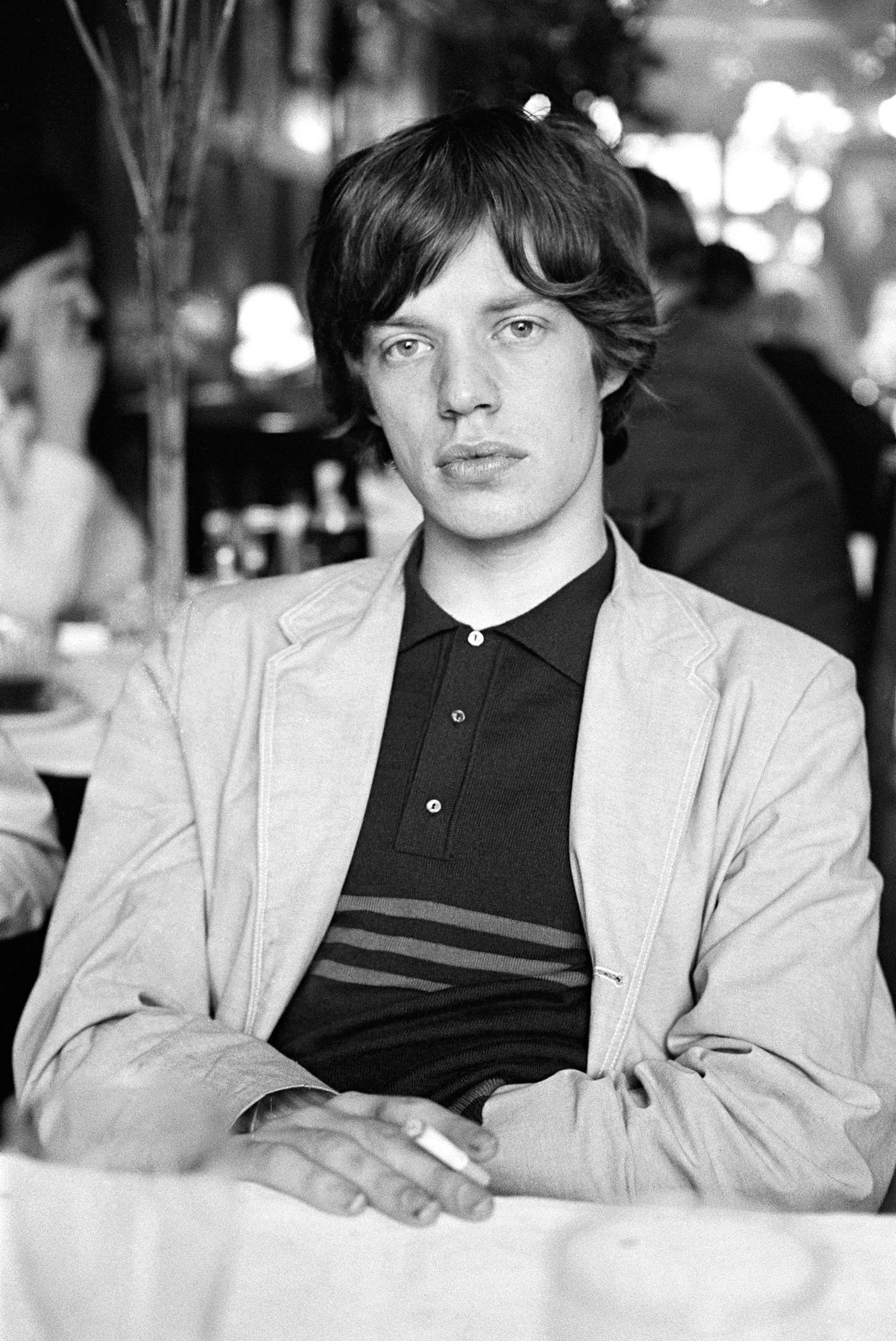 Rolling Stones singer Mick Jagger having a cigarette backstage; 1964.