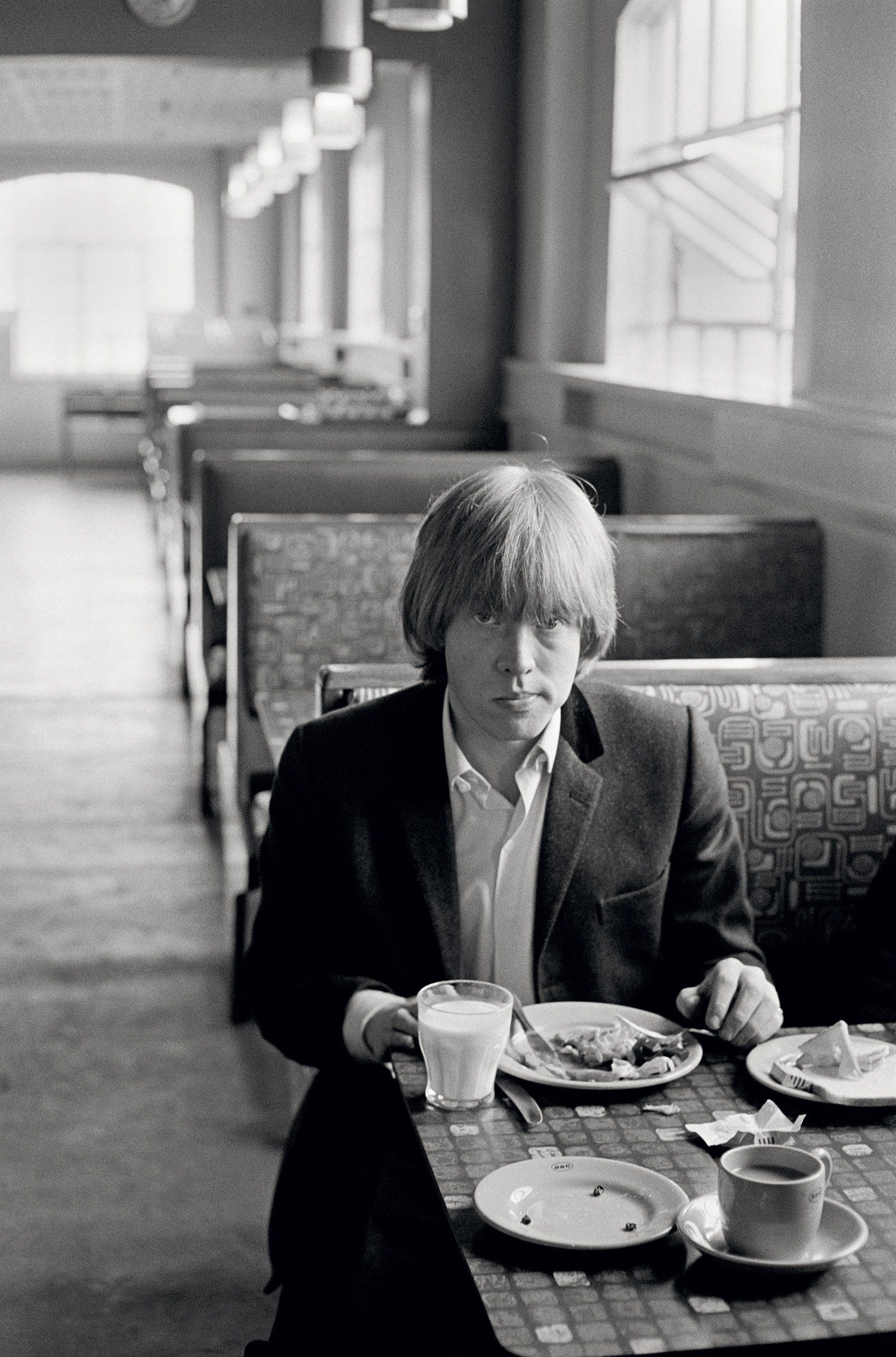 Guitarist Brian Jones of the Rolling Stones has a glass of milk in a motorway cafe, 1964.