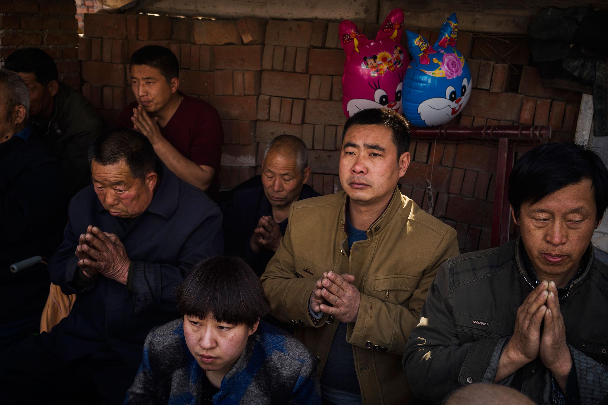 Villagers pray at an underground Easter Sunday Mass led by dissident Catholic Priest Dong Baolu in the yard of his house in Youtong village, Shijiazhuang, China, March 27, 2016.