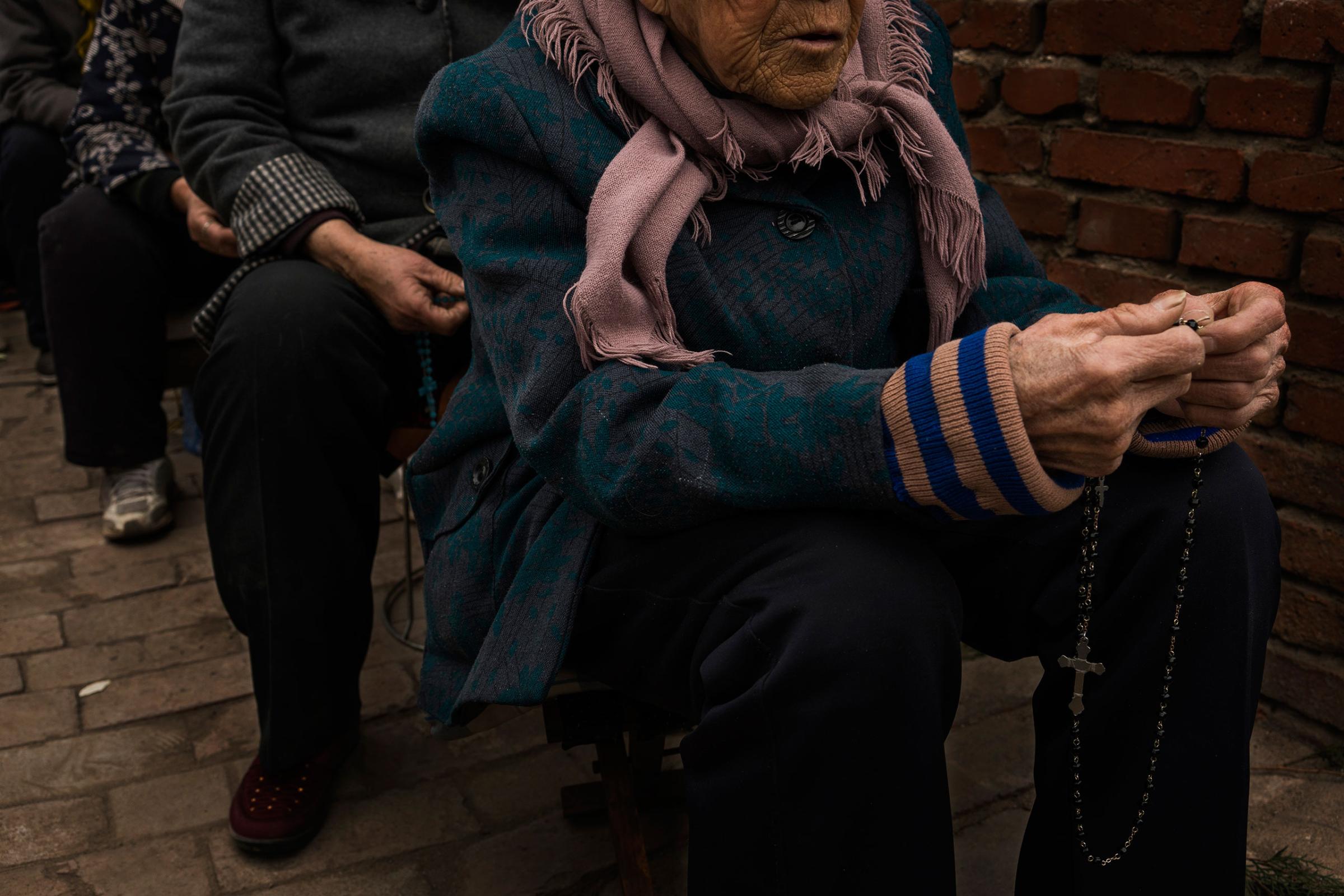 A parishioner thumbs her Rosemary beads during an underground Palm Sunday service in the yard of a house in Youtong village, Shijiazhuang, China, March 20, 2016