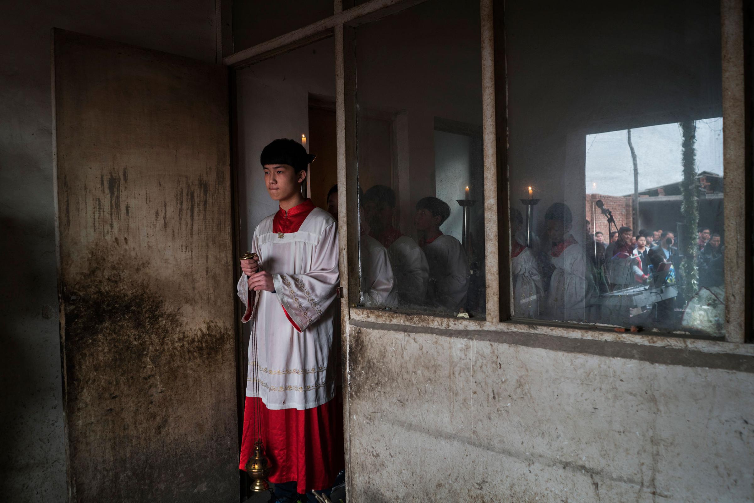 Altar boys prepare for an underground Palm Sunday service led by dissident Catholic Priest Dong Baolu in the yard of a house in Youtong village, Shijiazhuang, China, March 20, 2016.
