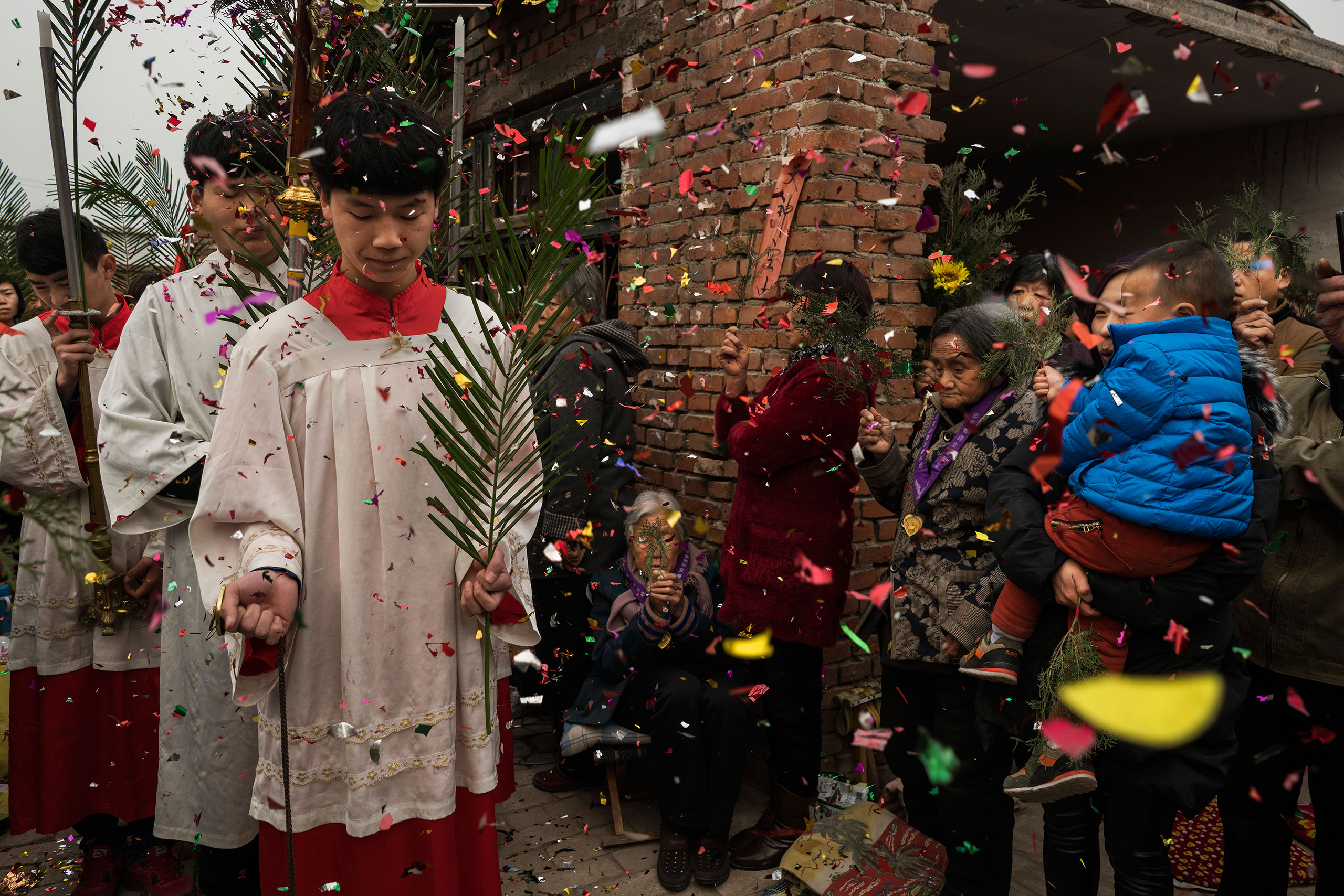 Altar boys during a procession through the congregation at an underground Palm Sunday service in the yard of a house in Youtong village, Shijiazhuang, China, March 20, 2016.