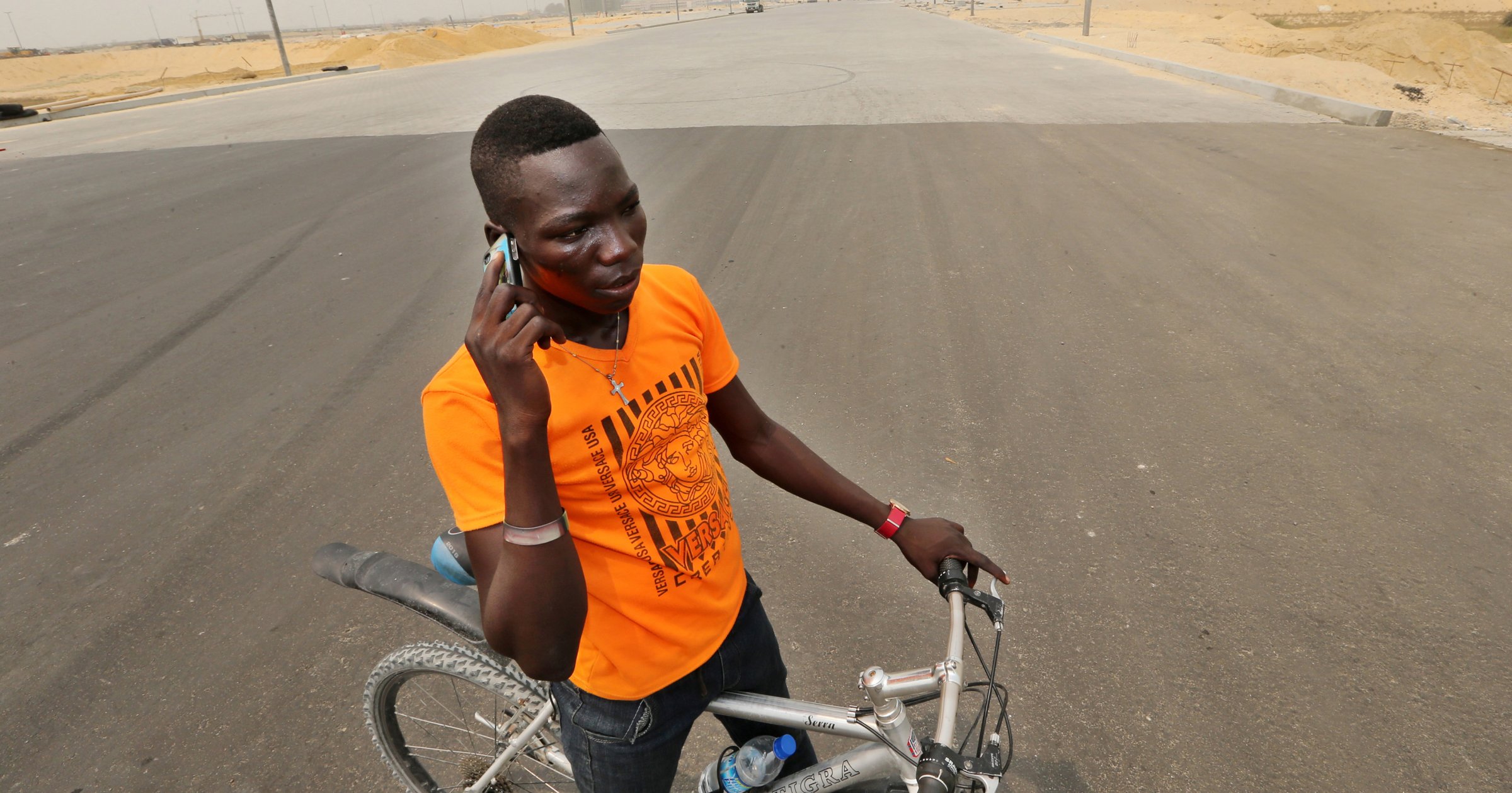 A cyclist stops to make a mobile phone call on a newly surfaced boulevard at the Eko Atlantic City site, developed by Eko Atlantic, near Victoria Island in Lagos, Nigeria on Feb. 12, 2016.