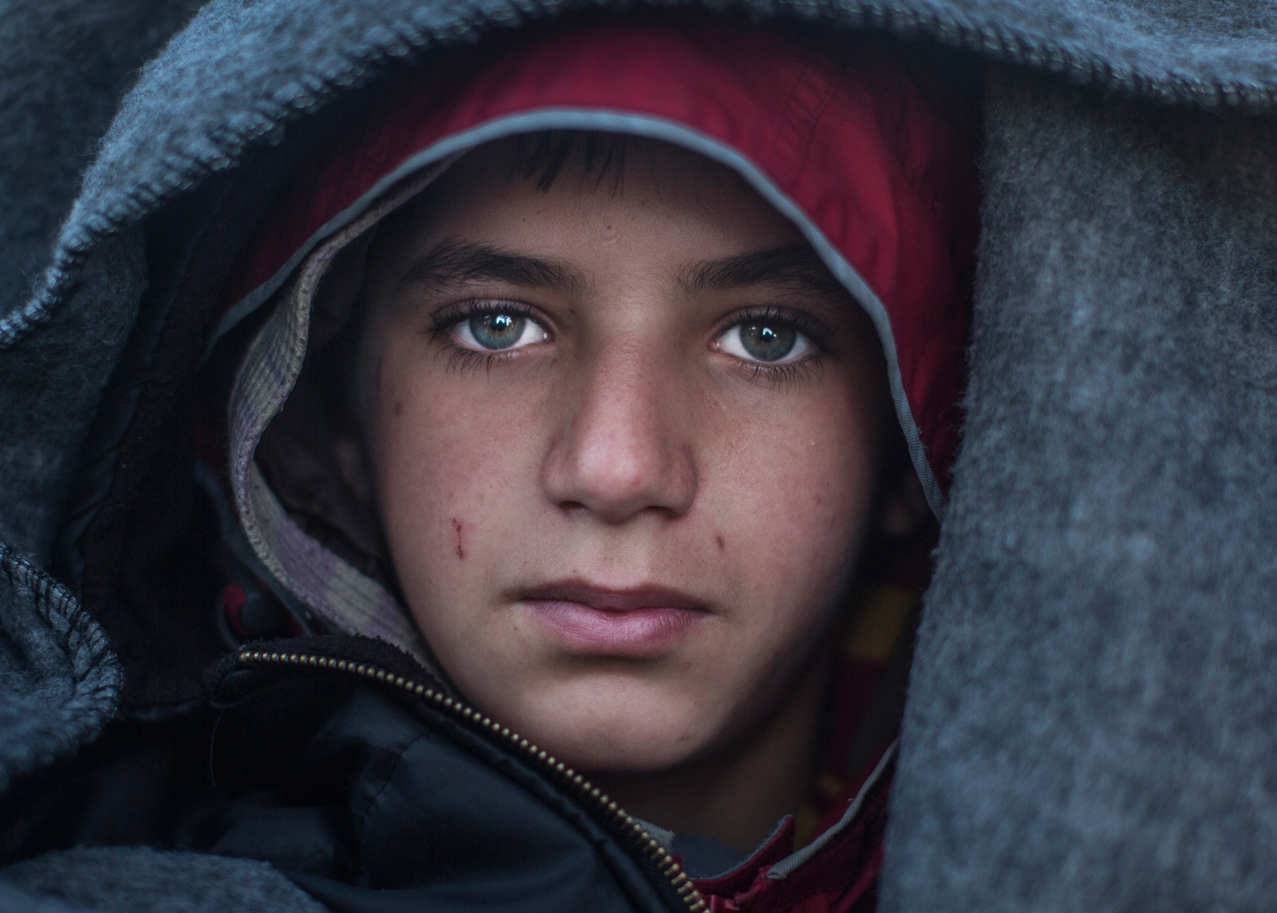 An 11-year-old Syrian refugee named Ahmed waits in line for a map directing asylum-seekers north at an encampment near the Greek village of Idomeni, March 4, 2016. (Ali Ali)