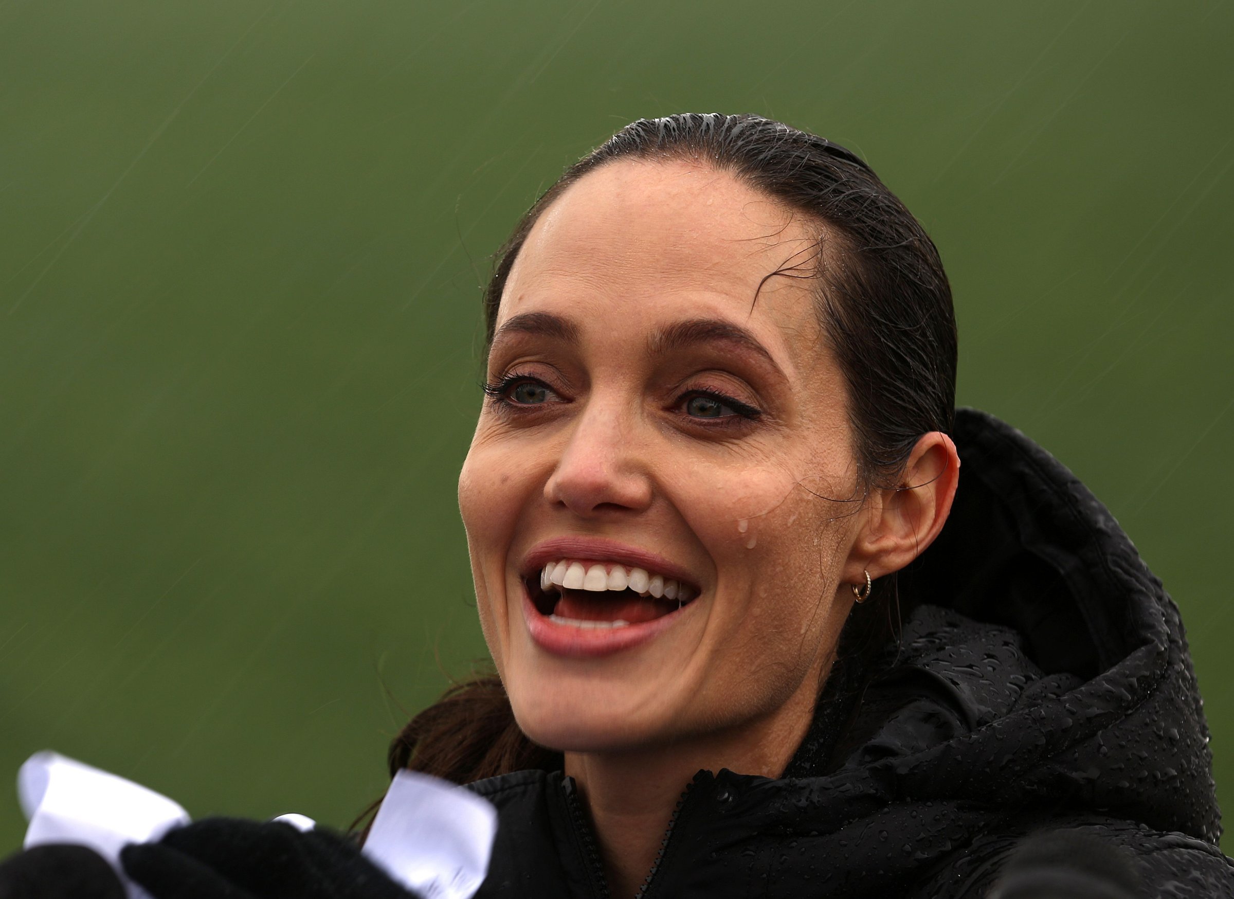 Special envoy of the UN High Commissioner for Refugees, US actress Angelina Jolie reacts during a press conference under the rain as part of her visit at a Syrian refugee camp near the city of Zahle in Lebanon's Bekaa Valley on March 15, 2016.