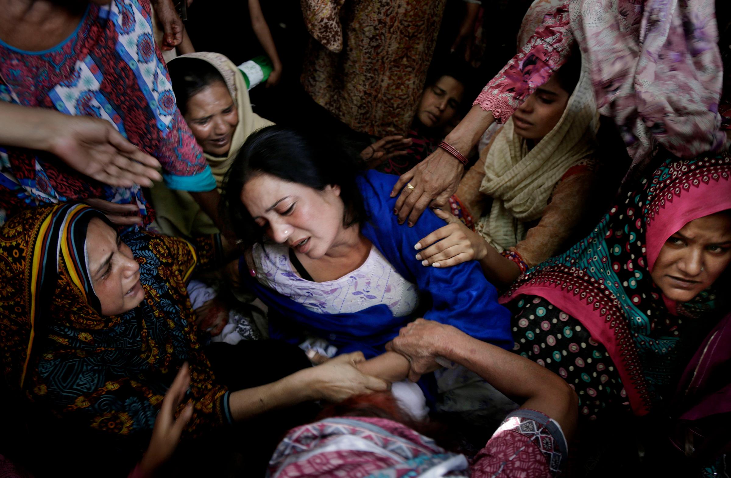 Women try to comfort a mother who lost her son in bomb attack in Lahore, Pakistan, March 28, 2016.