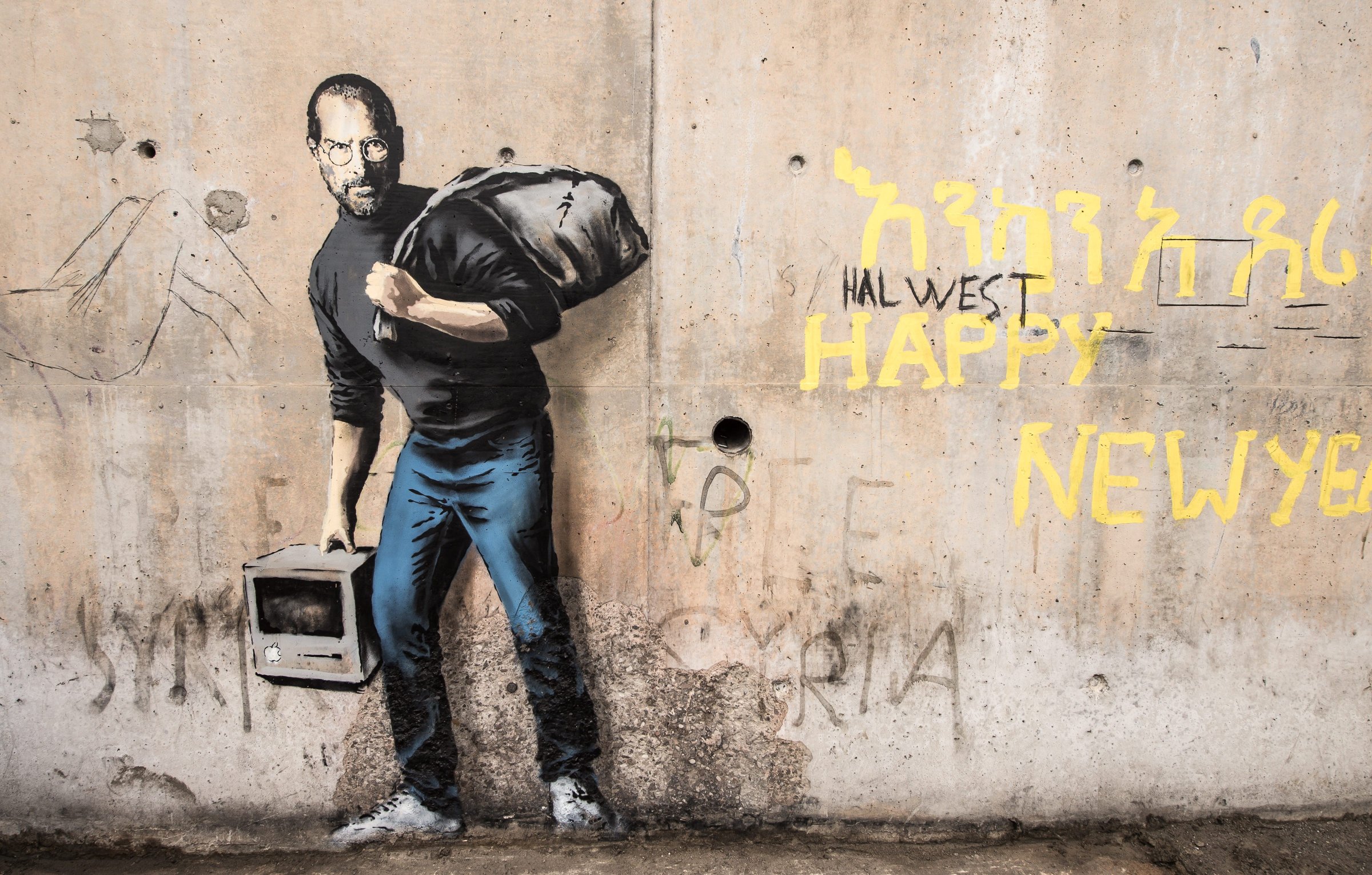 This picture taken on December 12, 2015 shows a street art graffiti representing Steve Jobs, founder and late CEO of Apple, by elusive British artist Banksy at the migrant camp known as the "Jungle" in Calais, northern France.
