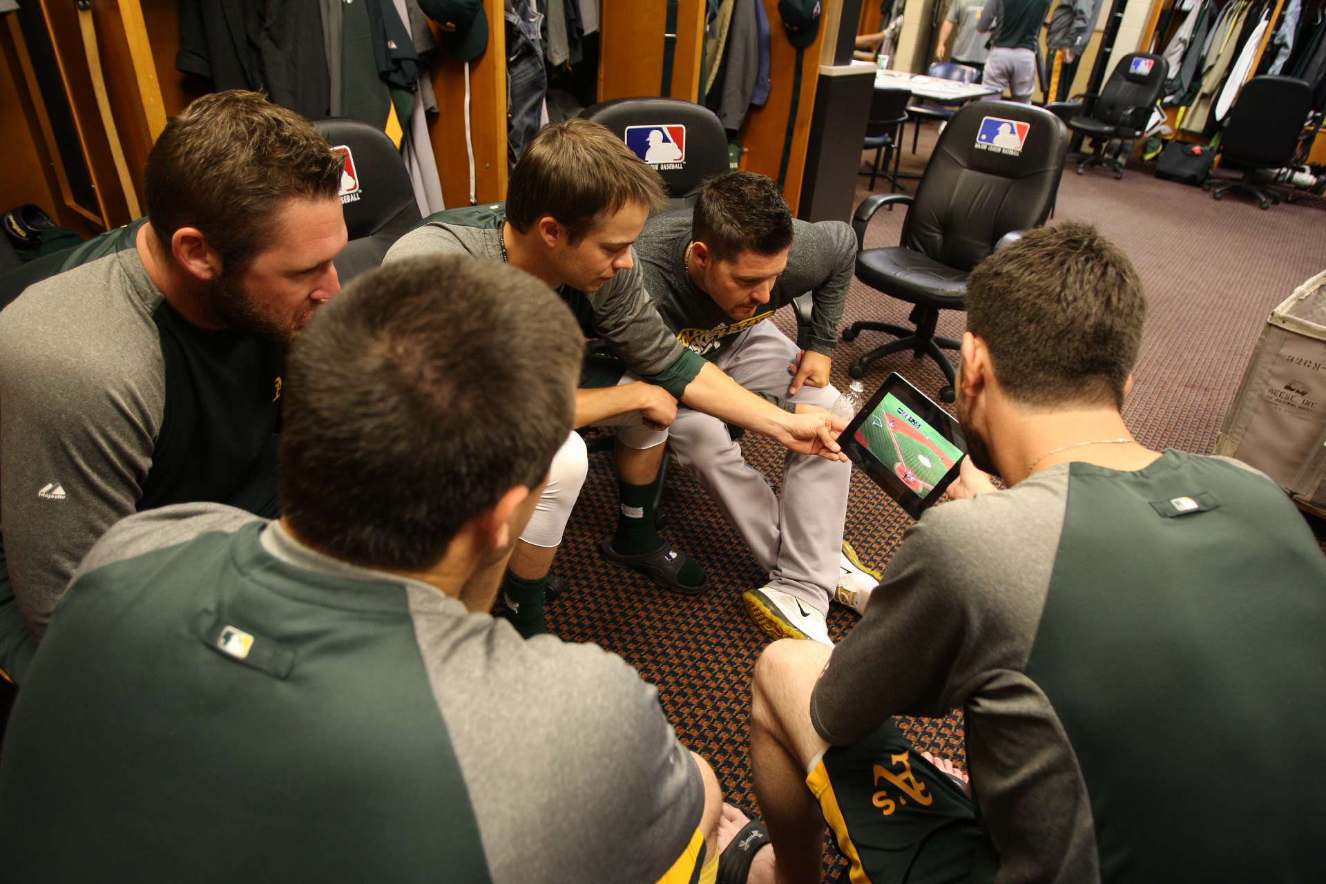 Members of the Oakland Athletics pitching staff watch highlights of the Athletics on an iPad in the clubhouse prior to the game against the Detroit Tigers at Comerica Park on October 6, 2012 in Detroit, Michigan.