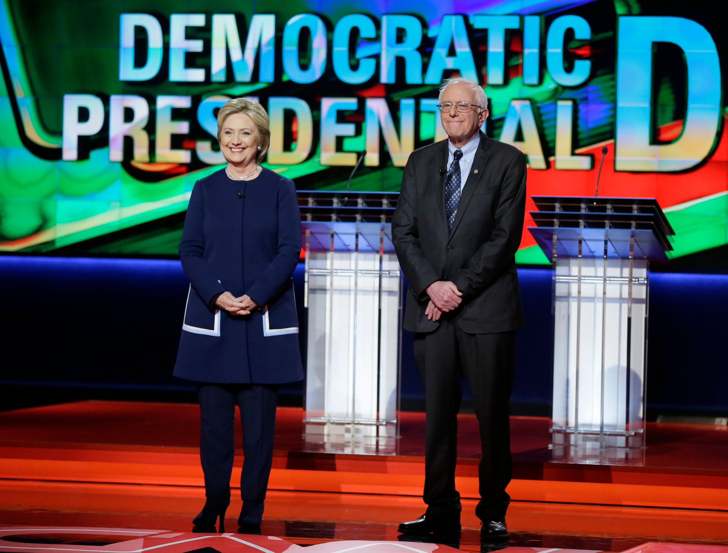 Hillary Clinton and Bernie Sanders stand stage before a Democratic presidential primary debate at the University of Michigan-Flint in Flint, Mich. on March 6, 2016.