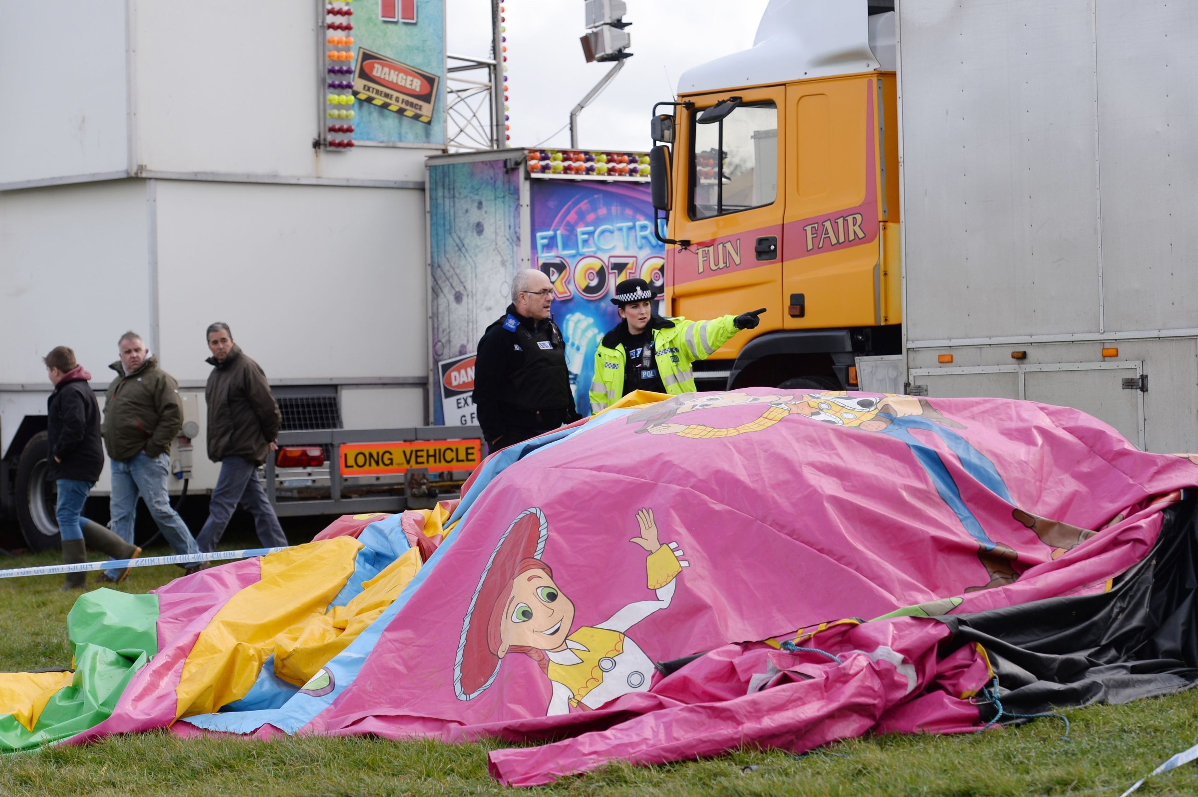 Police and forensic officers attend the scene where a seven-year old girl died after she was blown by the wind about 150 metres on a bouncy castle on March 27, 2016.
