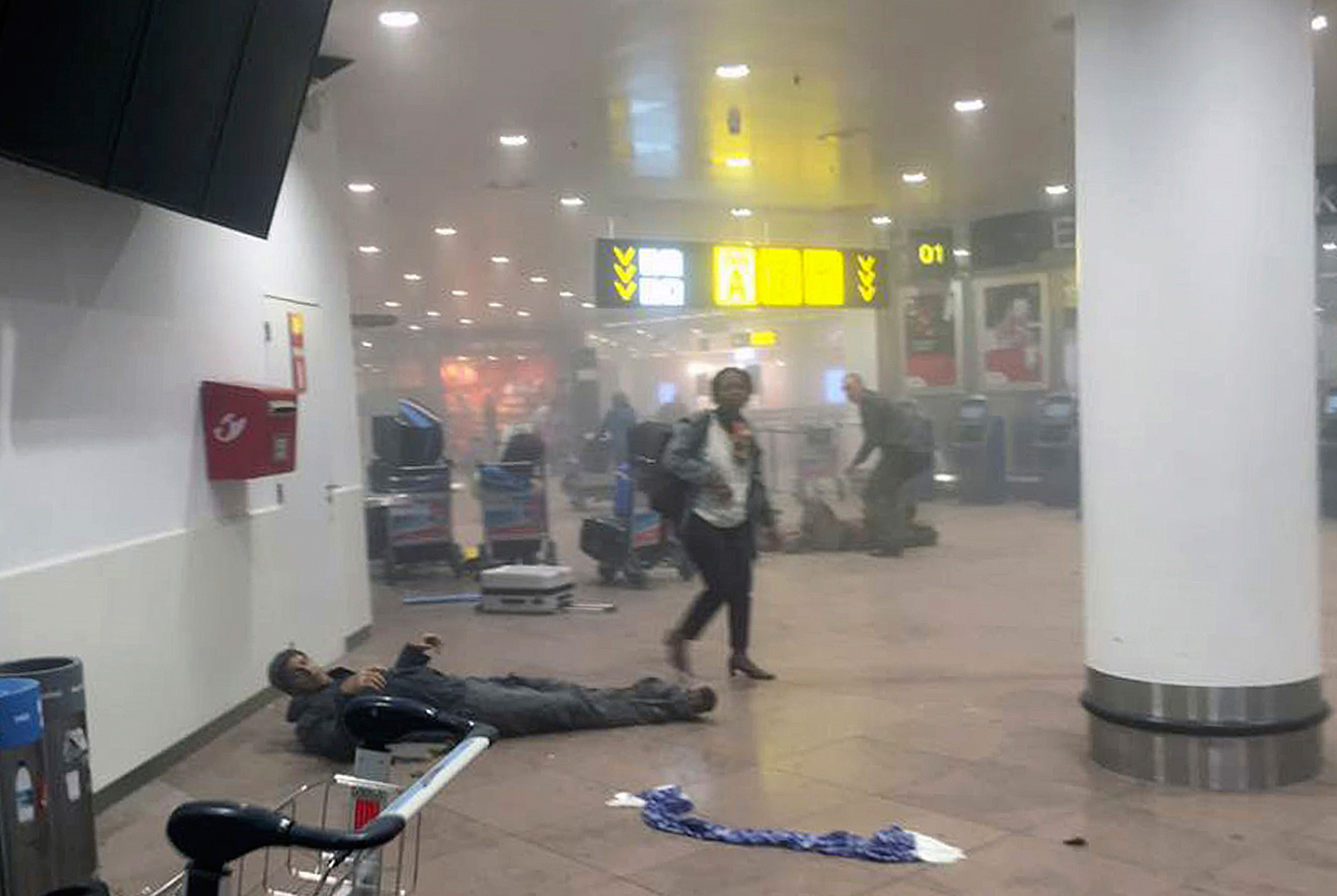 A wounded man lays on the ground after a bomb blast at the airport in Brussels on March 22, 2016 (Ketevan Kardava—Georgian Public Broadcaster/AP)