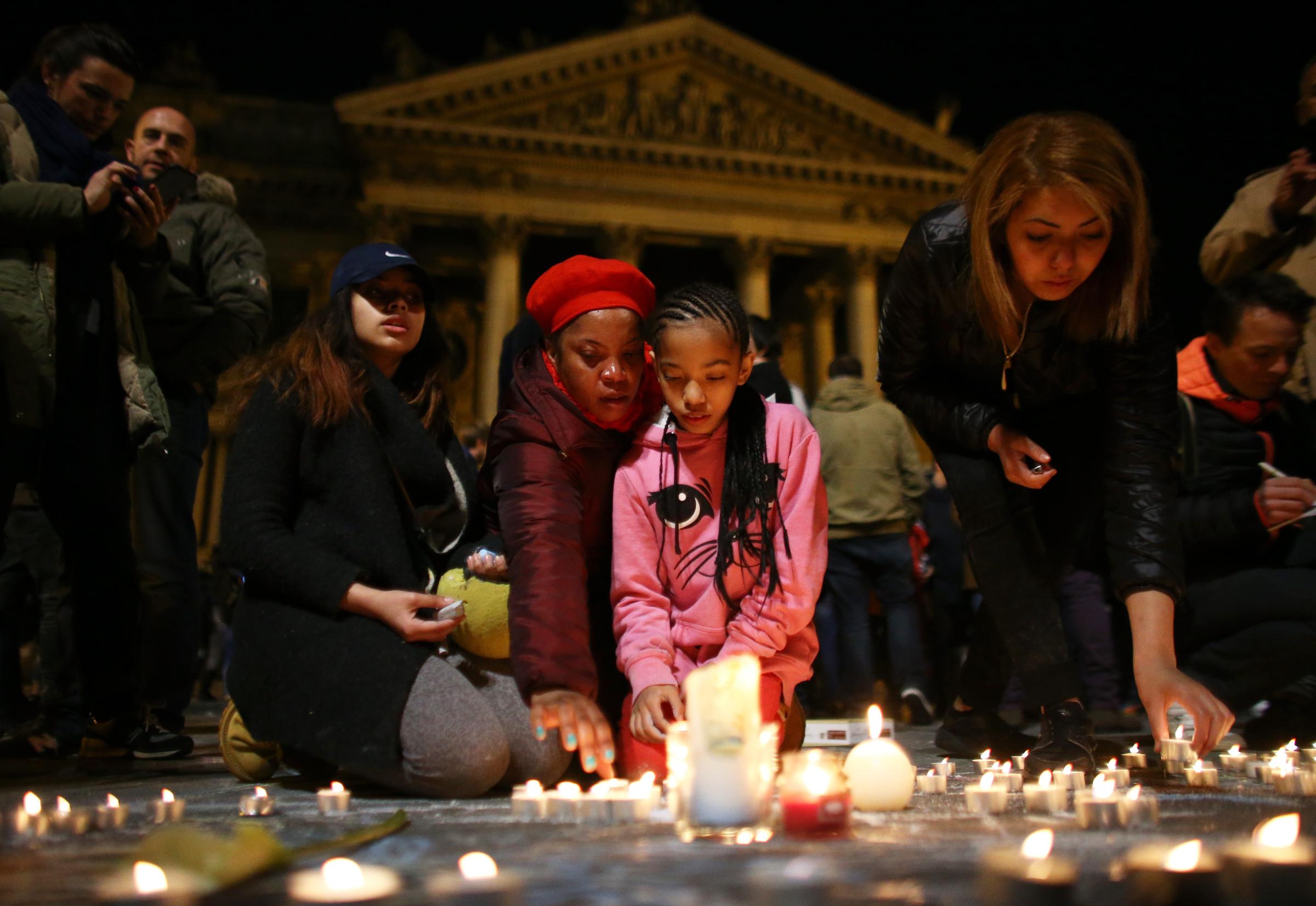 A young girl lights a candle at the Place de la Bourse following the attacks on March 22, 2016 in Brussels, Belgium.