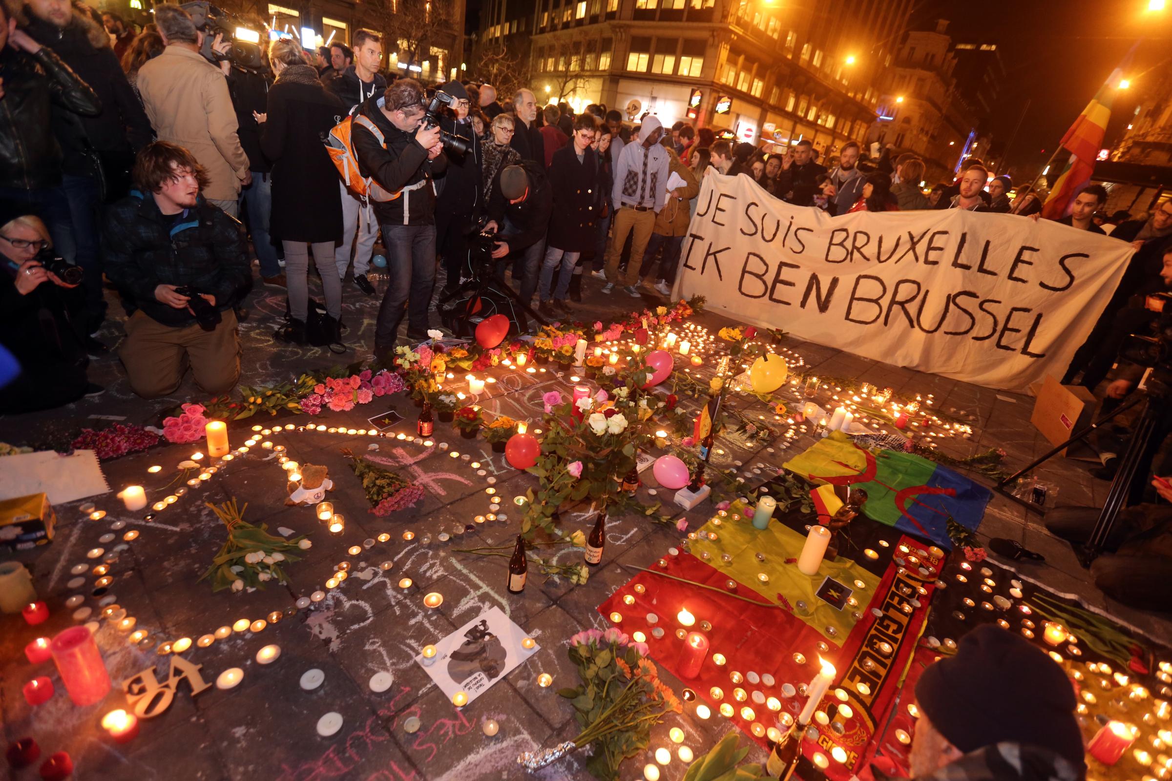 People gather to leave tributes at the Place de la Bourse following the terrorist attacks on March 22, 2016 in Brussels, Belgium.