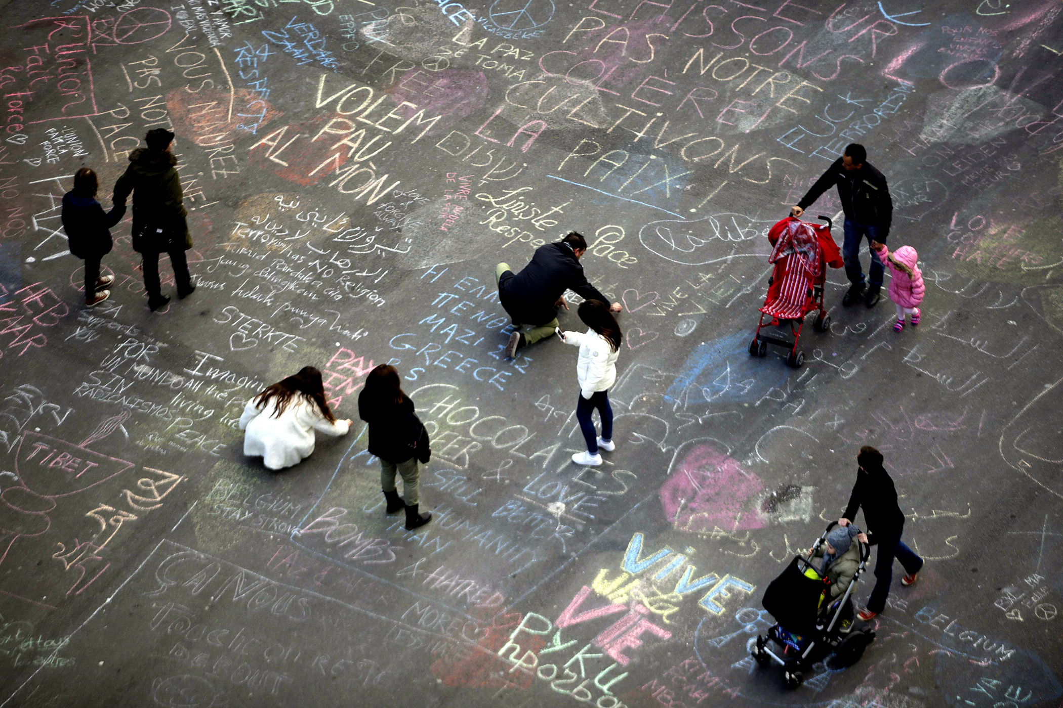 People write messages in chalk at Place de la Bourse following attacks in Brussels, Belgium, March 22, 2016.