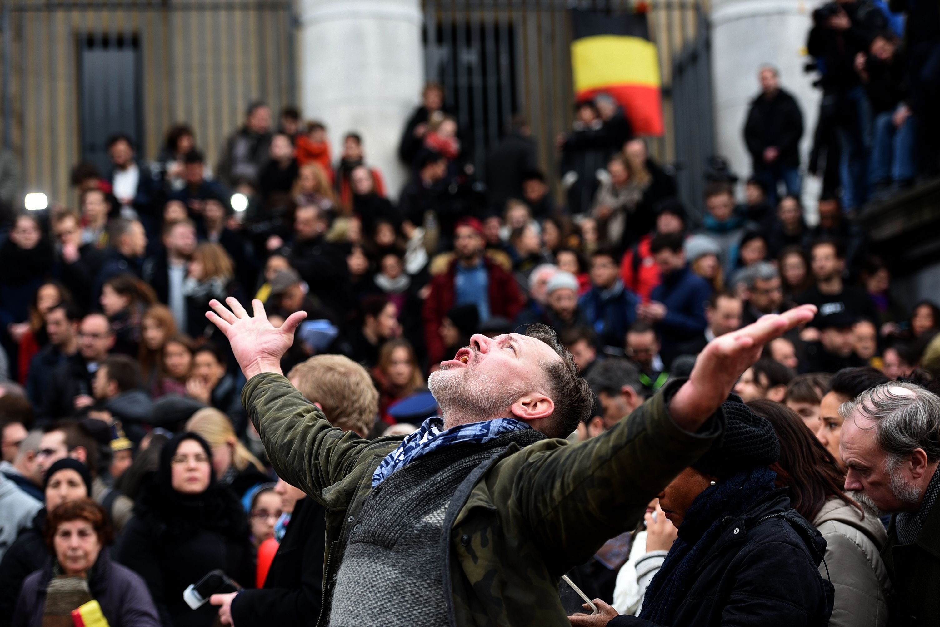 A man reacts as people gather to observe a minute of silence in memory of the victims of the Brussels airport and metro bombings, on March 23, 2016. (Patrik Syollarz—AFP/Getty Images)