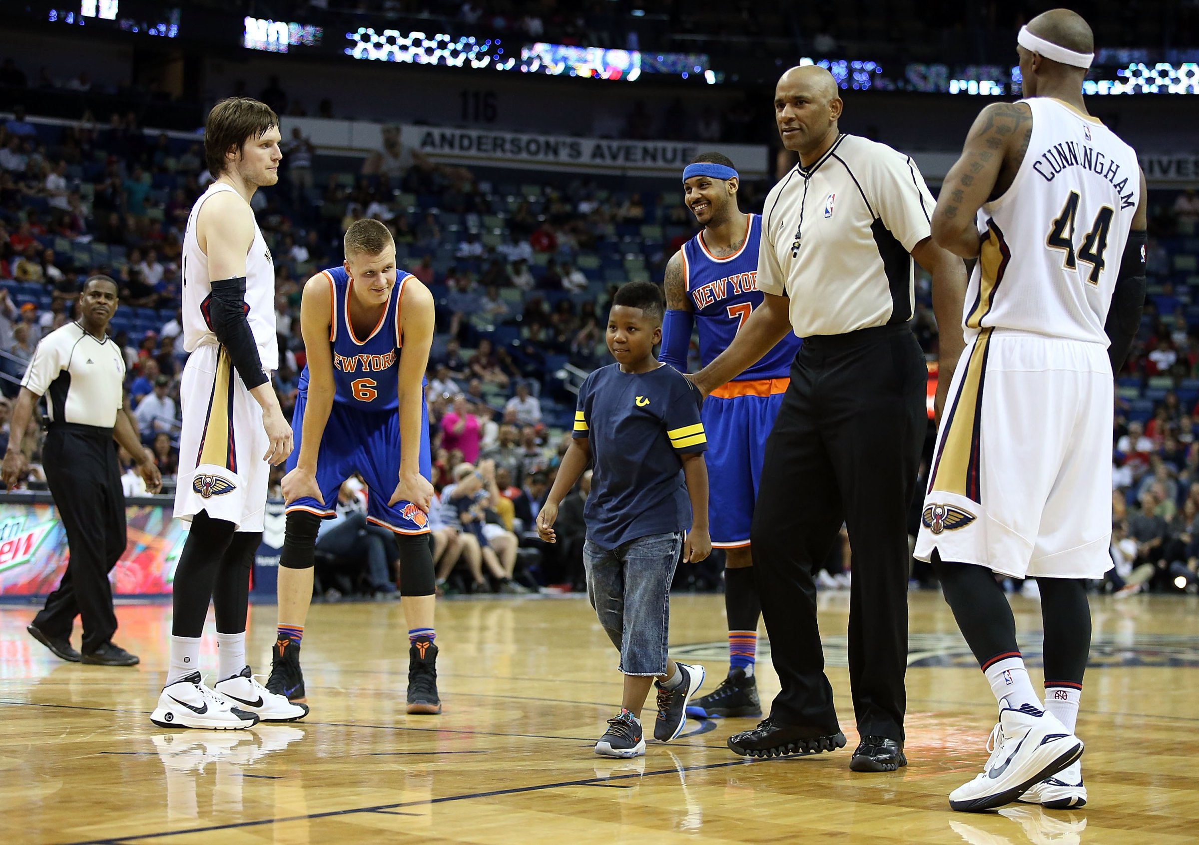 A young boy is escorted off the court after hugging Carmelo Anthony #7 of the New York Knicks during a game against the New Orleans Pelicans during the second half at the Smoothie King Center on March 28, 2016 in New Orleans, Louisiana.