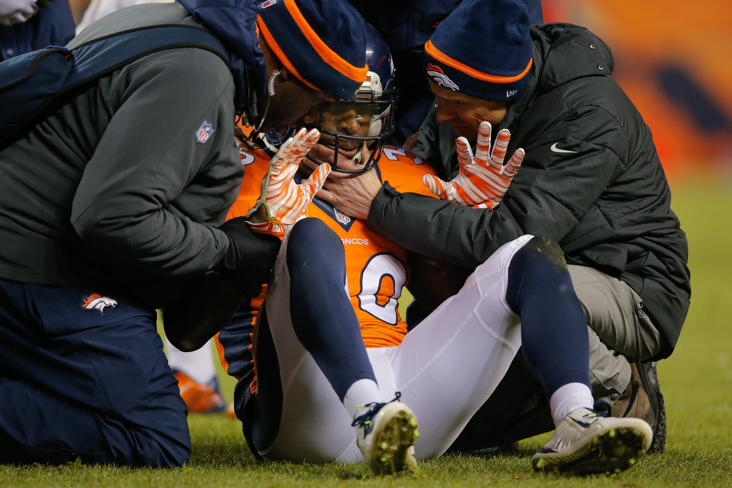 Strong safety David Bruton #30 of the Denver Broncos is attended to by trainers after a play that would force him out of the game with a reported concussion during a game against the Oakland Raiders at Sports Authority Field at Mile High on December 28, 2014 in Denver, Colorado.