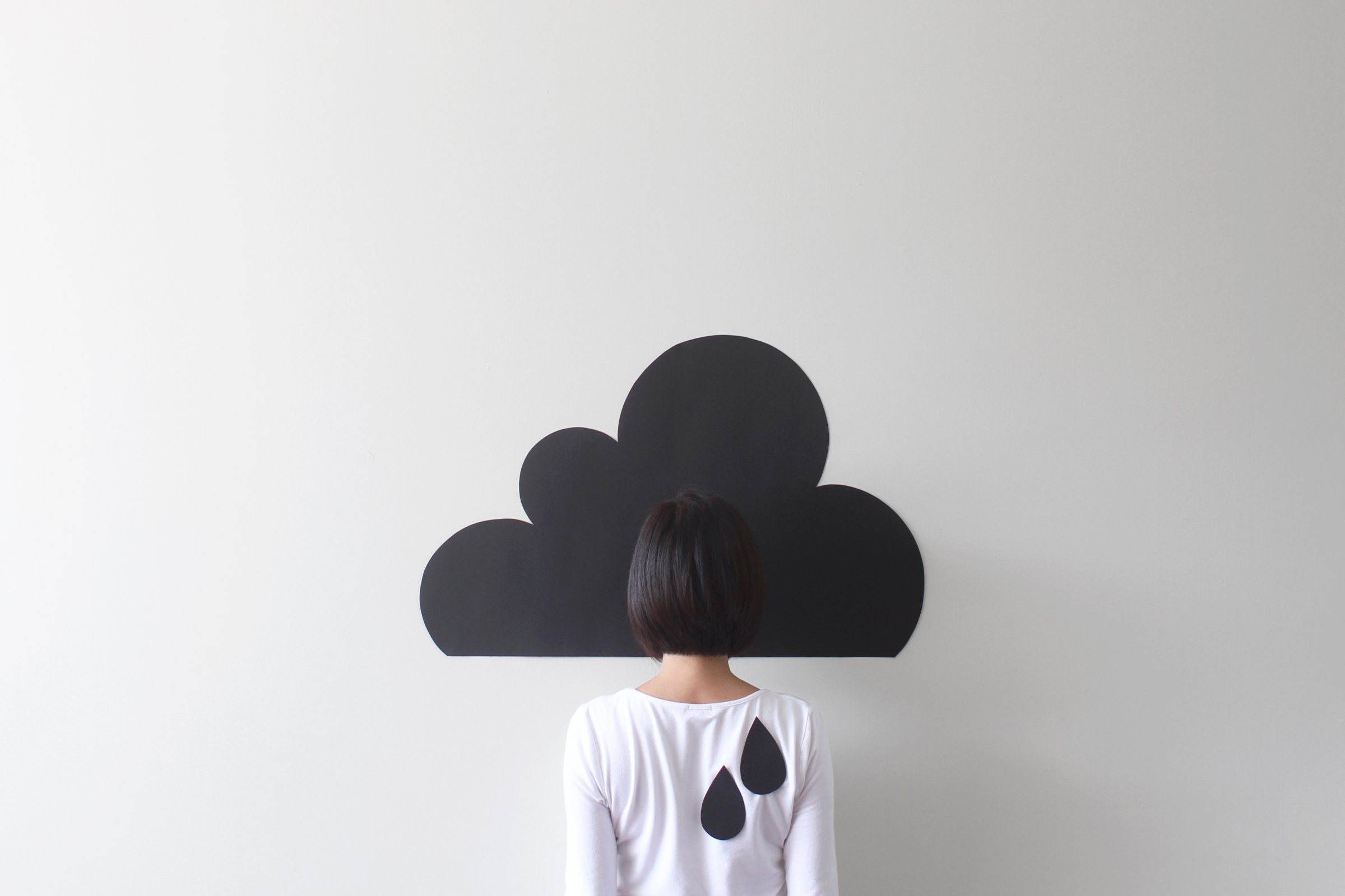 Rear view of a woman standing against conceptual rain cloud