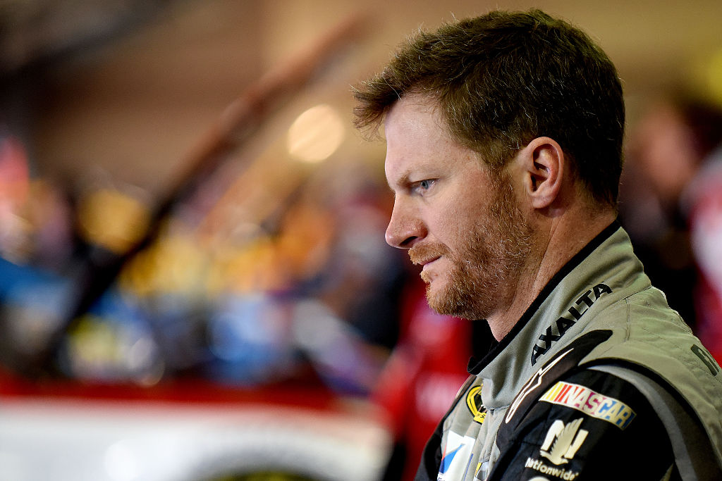 Dale Earnhardt Jr. stands in the garage area during practice for the NASCAR Sprint Cup Series Auto Club 400 at Auto Club Speedway on March 19, 2016 in Fontana, California.