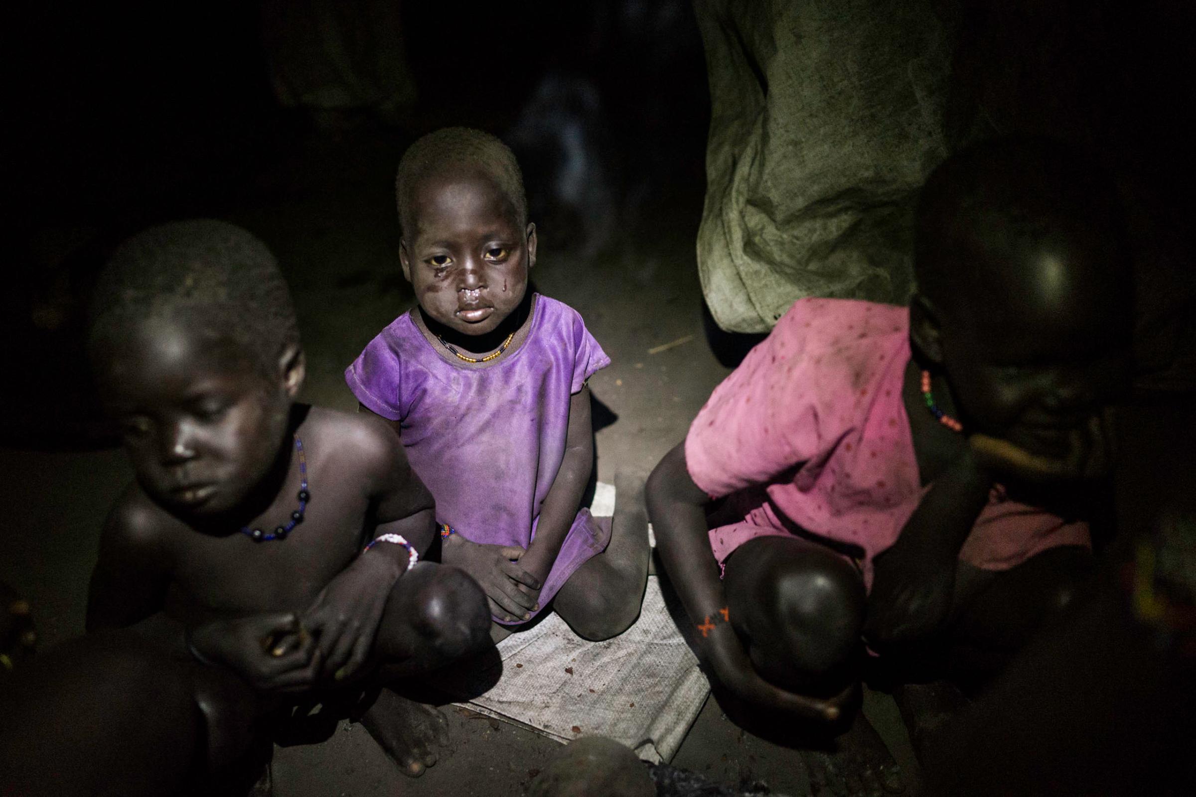 A child cries after walking through the cold swamps at night after collecting long awaited food distribution, Kok Island, Unity State, South Sudan.