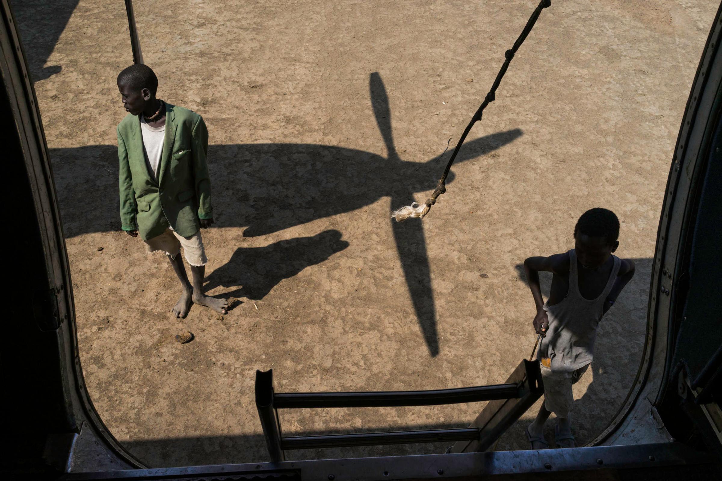 Two boys stand next to a plane that brought medical supplies to Doctors Without Borders in Leer, Unity State, South Sudan. Due to the continuing insecurity and lack of infrastructure, the only way to supply the rural hospital is by air.