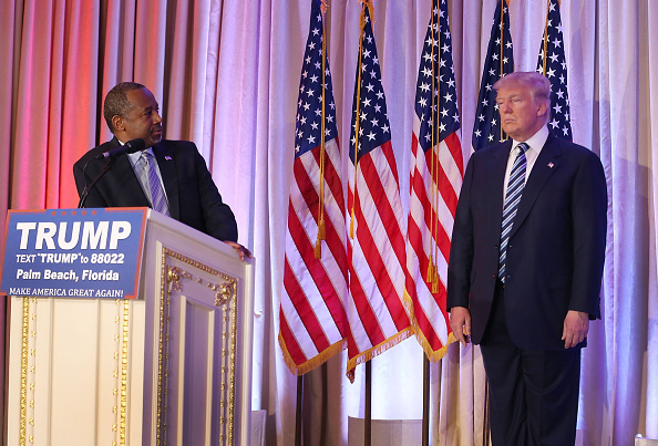 Former Republican presidential candidate Ben Carson looks back at Republican presidential candidate Donald Trump as he give him his endorsement at the Mar-A-Lago Club on March 11, 2016 in Palm Beach, Florida.