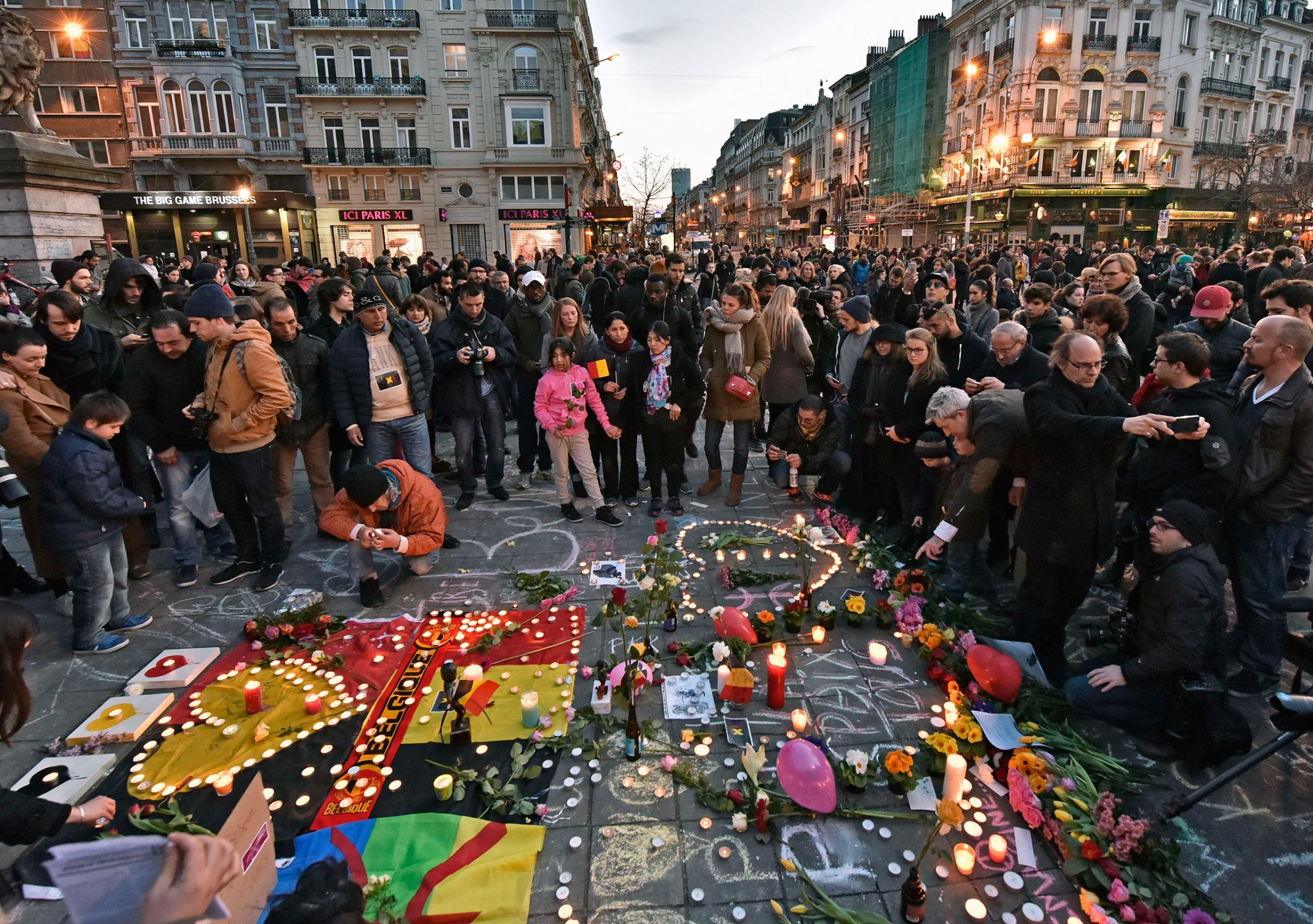 People bring flowers and candles to mourn at the Place de la Bourse in the center of Brussels, Belgium, March 22, 2016.