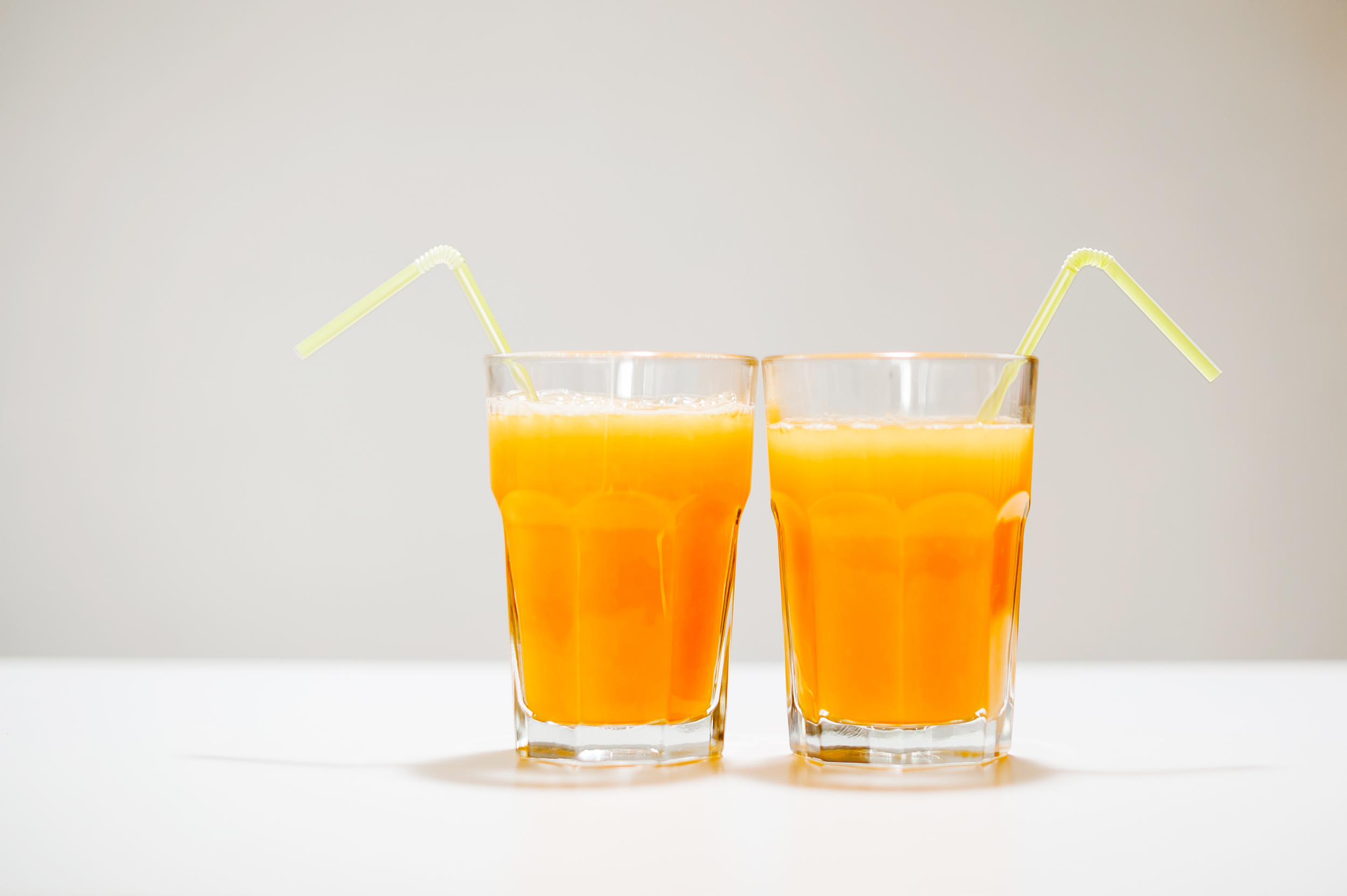 Two glass of orange juice with straw
