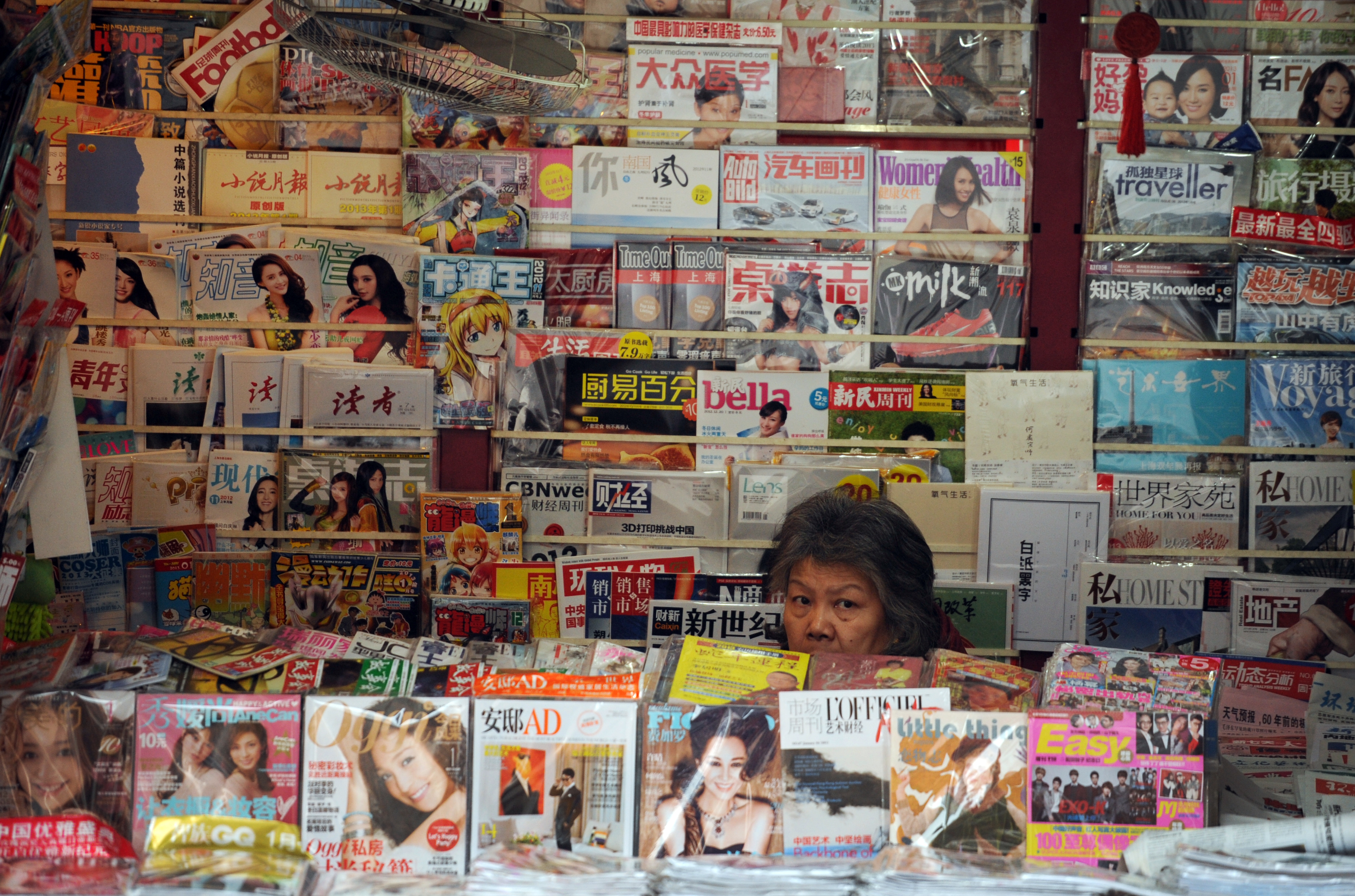 A newspaper vendor looks out from her booth on a street in Shanghai on Jan. 8, 2013 (Peter Parks—AFP/Getty Images)