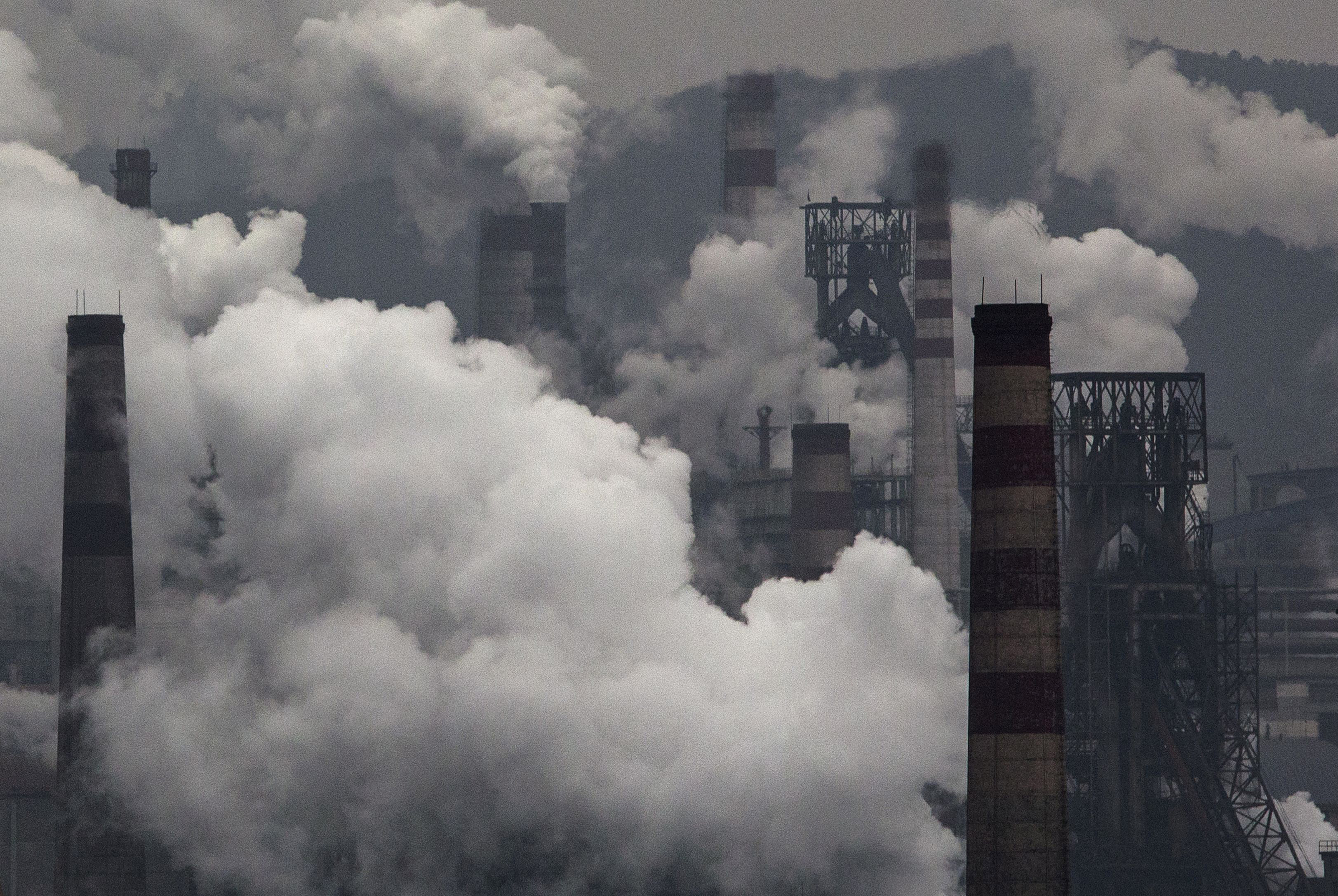 Smoke billows from smokestacks and a coal-fired generator at a steel factory on Nov. 19, 2015, in China's industrial province of Hebei (Kevin Frayer—Getty Images)