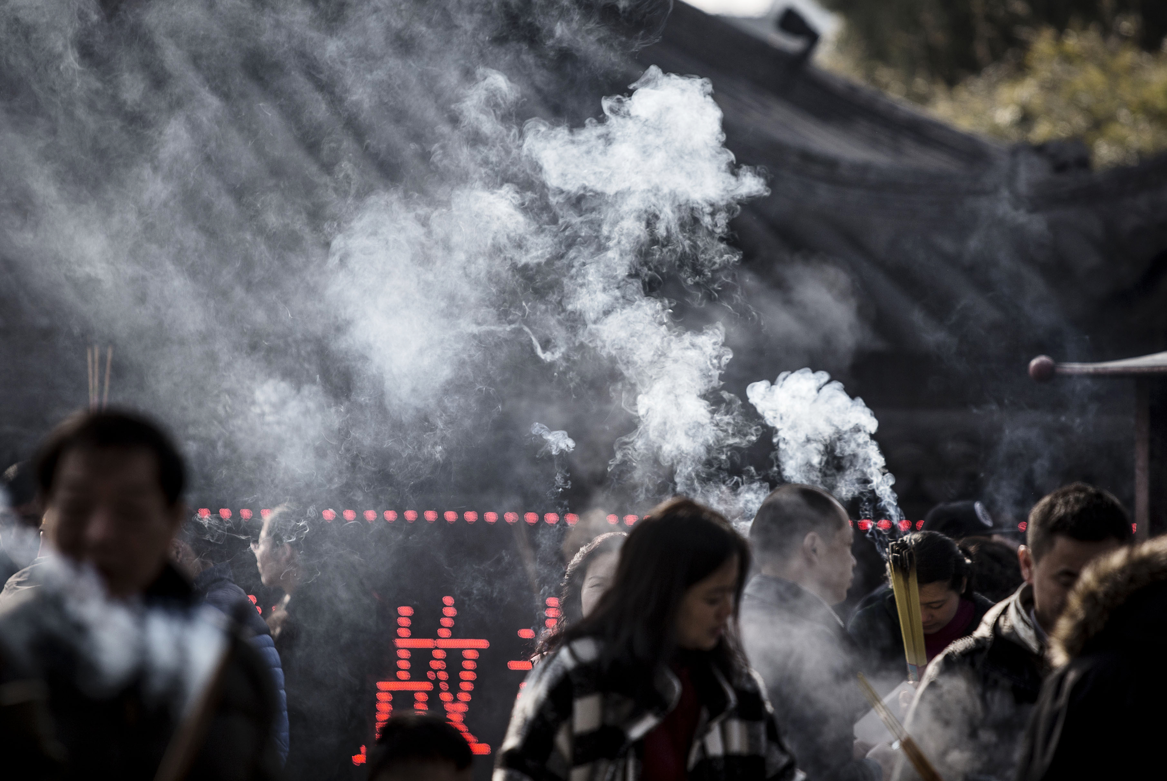 Worshipers pray and make offerings of incense sticks at Longhua Temple in Shanghai, China, on Tuesday, Feb. 9, 2016. (Bloomberg via Getty Images)