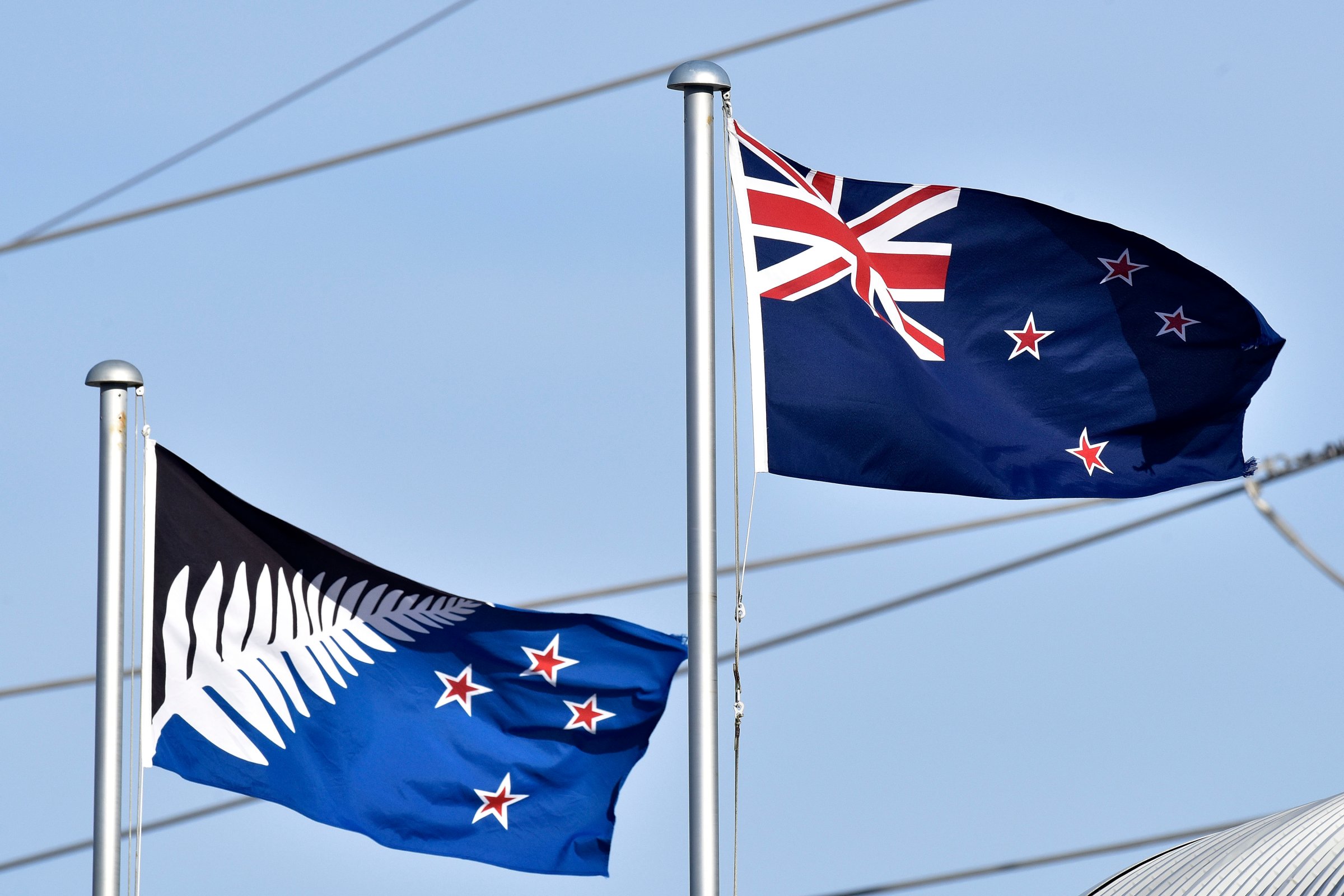 The current New Zealand flag, right, flutters next to the proposed new flag in Wellington, New Zealand, March 4, 2016.