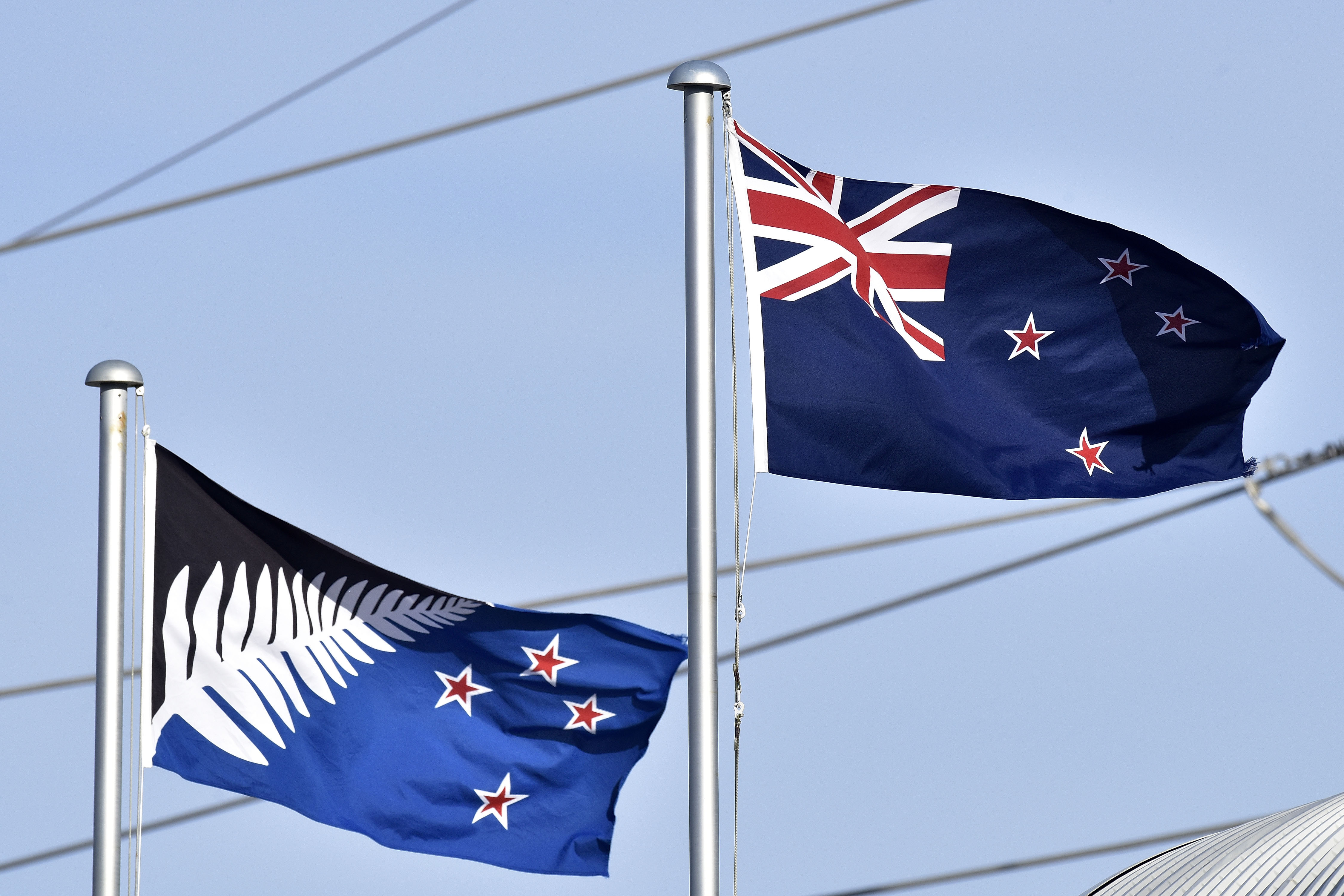 The current New Zealand flag, right, flutters next to the proposed new flag in Wellington, New Zealand, March 4, 2016. (Marty Melville—AFP/Getty Images)
