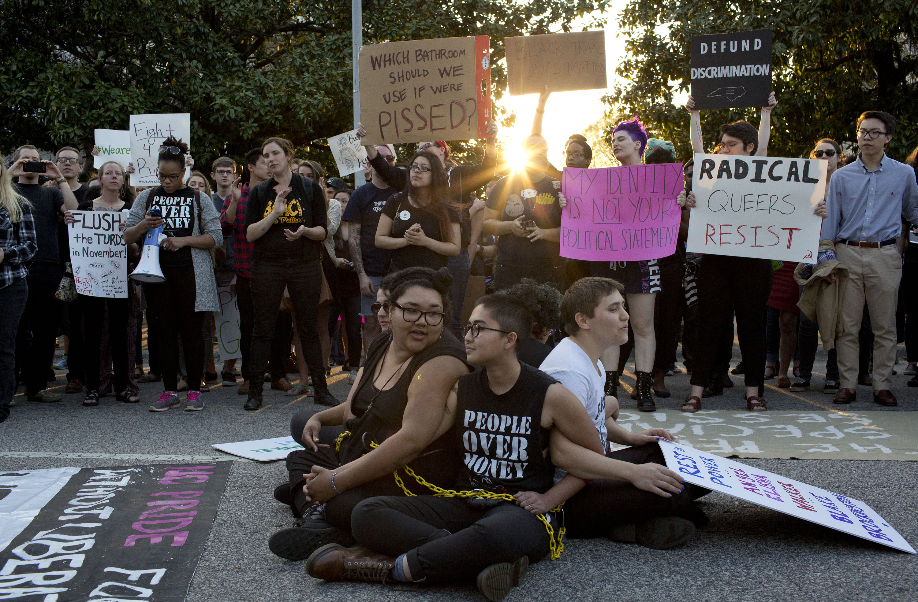 Front from left, demonstrators Jess Jude, Loan Tran and Noah Rubin-Blose, sit chained together in the middle of the street during a protest against House Bill 2 outside of the Governor's Mansion in Raleigh, N.C., on  March 24, 2016,.