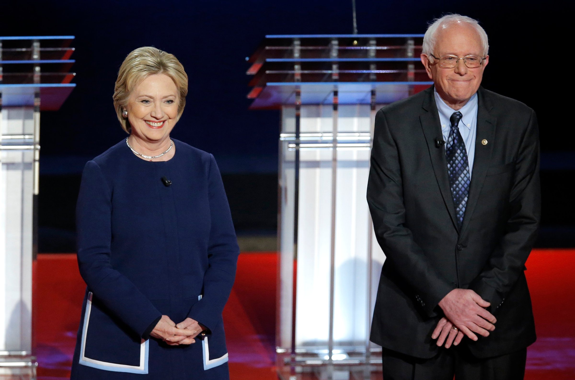 Hillary Clinton and Bernie Sanders pose together onstage at the start of the U.S. Democratic presidential candidates' debate in Flint, Michi. on March 6, 2016.