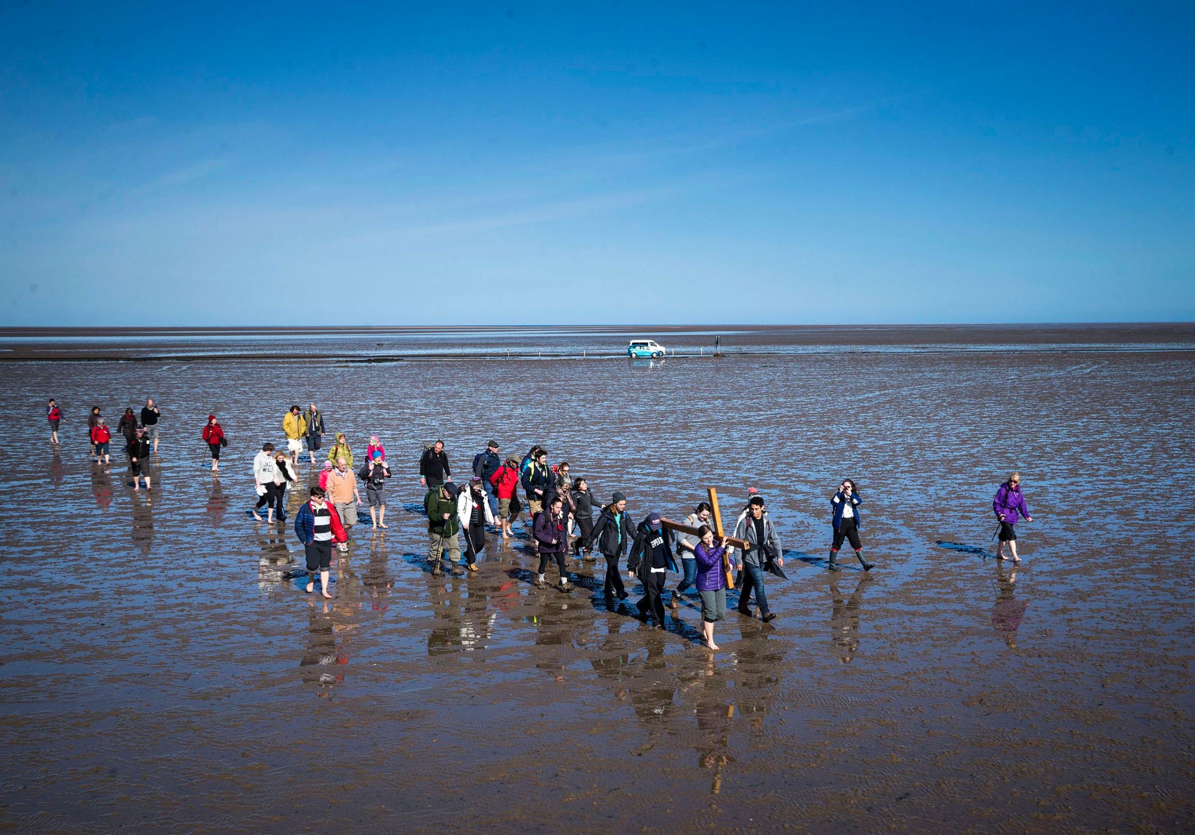 Pilgrims carry a cross on the final leg of the Northern Cross pilgrimage to Holy Island near Berwick-upon-Tweed in Northumberland, England, March 25, 2016.
