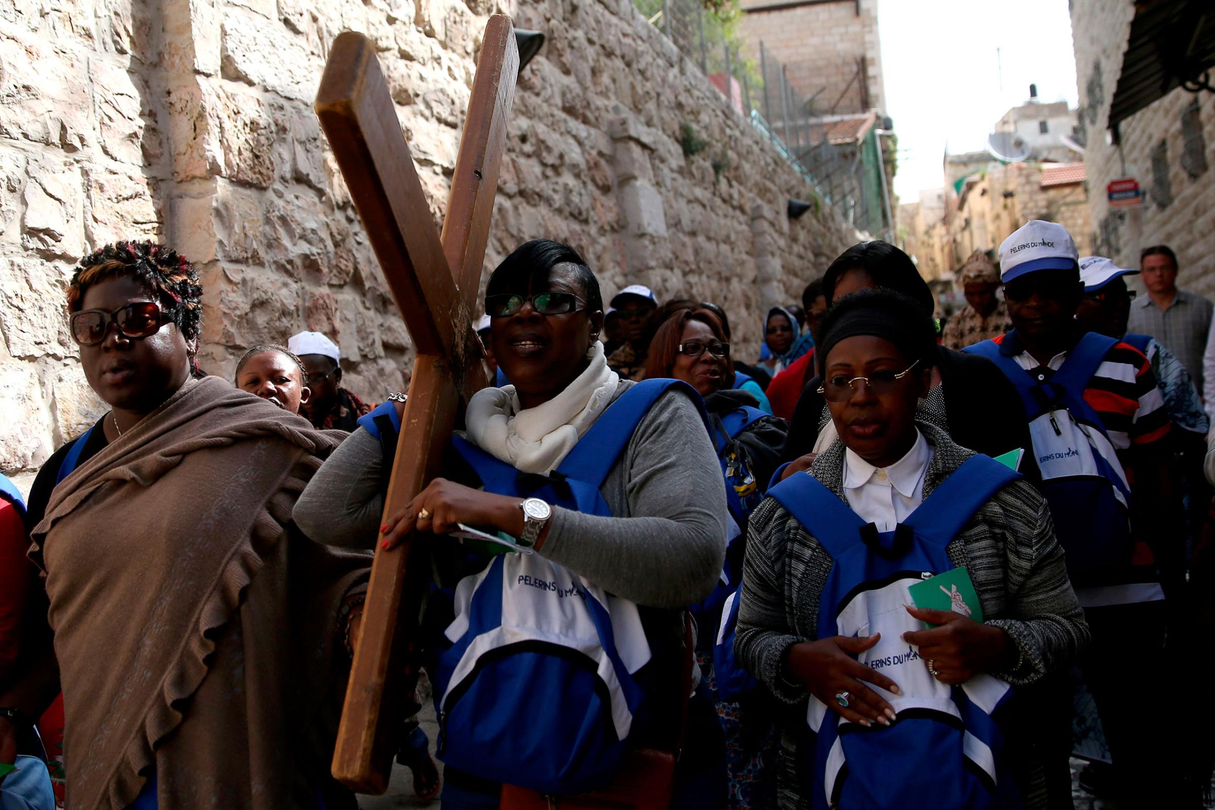 Catholic pilgrims from the Ivory Cost carry a wooden cross along the Via Dolorosa (Way of Suffering) during the Good Friday procession in the Jerusalem's Old City of Jerusalem, March 25, 2016.