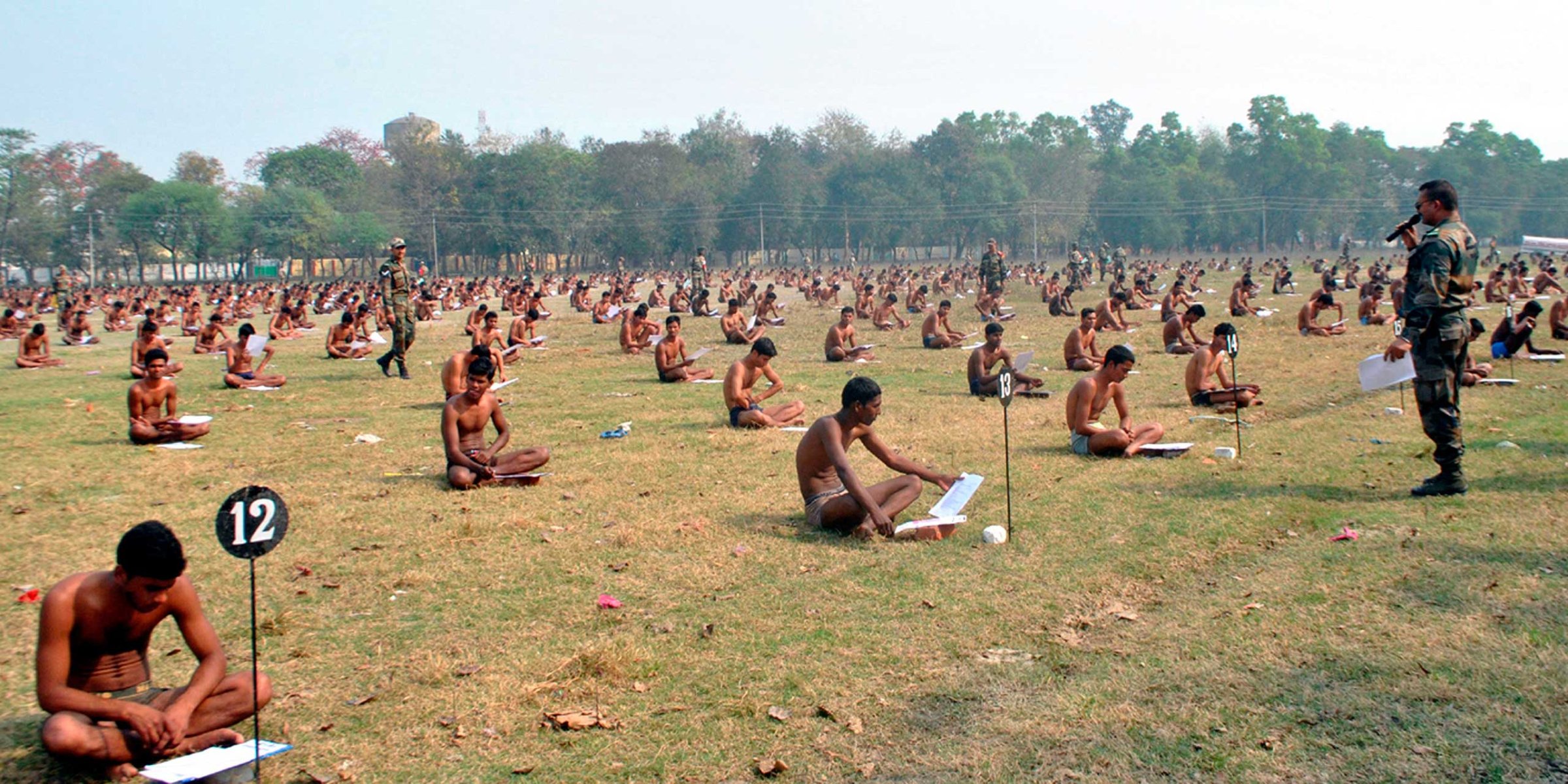 Indian army candidates sit in their underwear as they take a written exam in a field after being asked to remove their clothing to deter cheating in Muzaffarpur, India, Feb. 28, 2016.