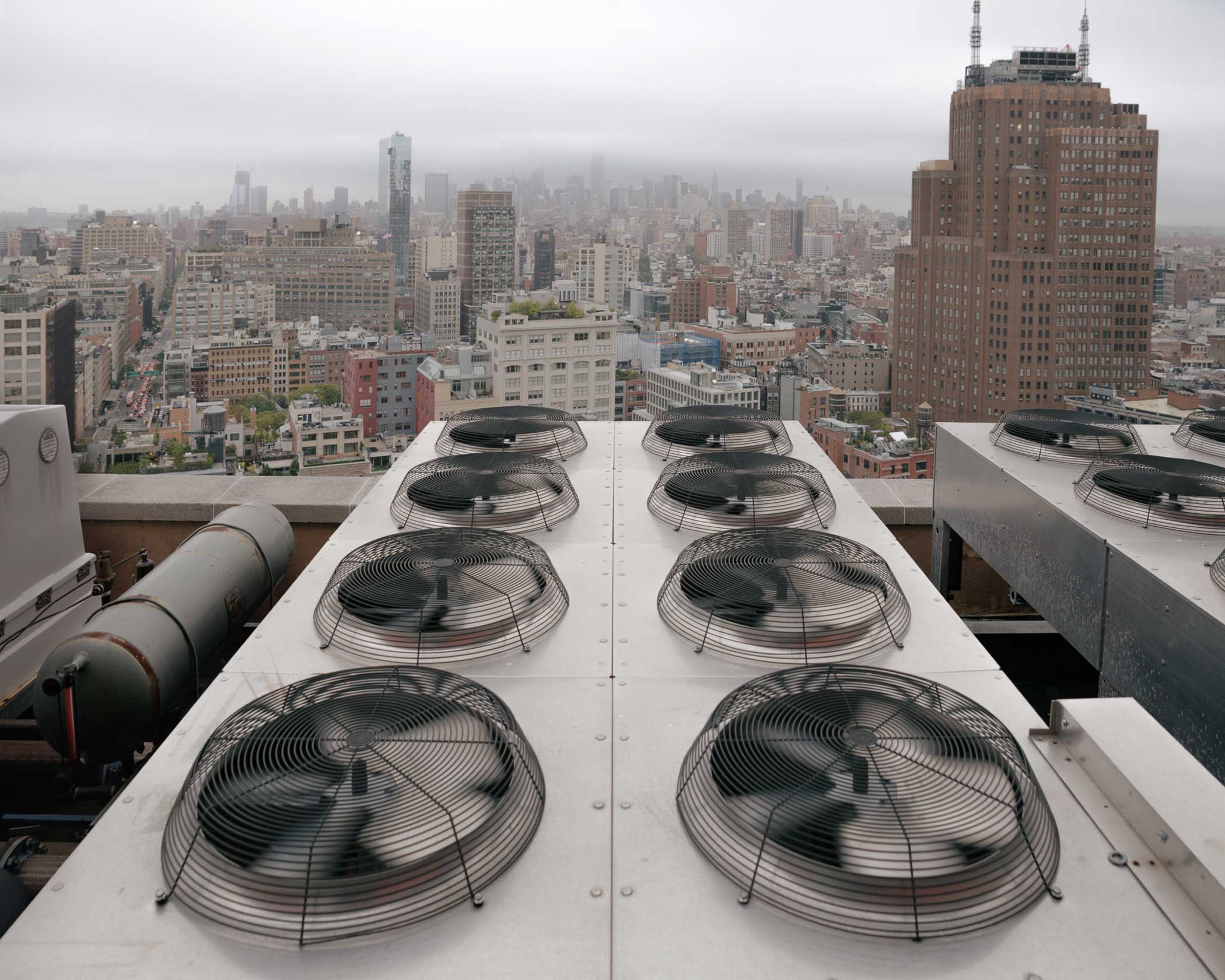 Fans move heat exhaust off the roof at 60 Hudson Street. Nearby, the large brick AT&amp;T Long Distance Building at 32 Avenue of the Americas (foreground, right) is also host to a dense hub of Internet infrastructure, colocation centers and peering exchanges.