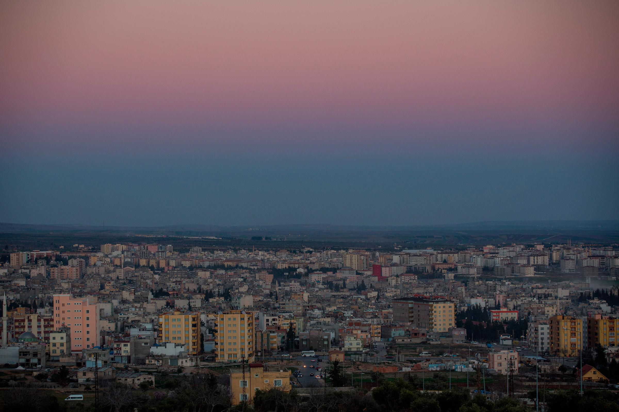 The sun sets on the city of Kilis, which lies along Turkey's southern border with Syria and includes the Oncupinar Crossing, March 1, 2016.