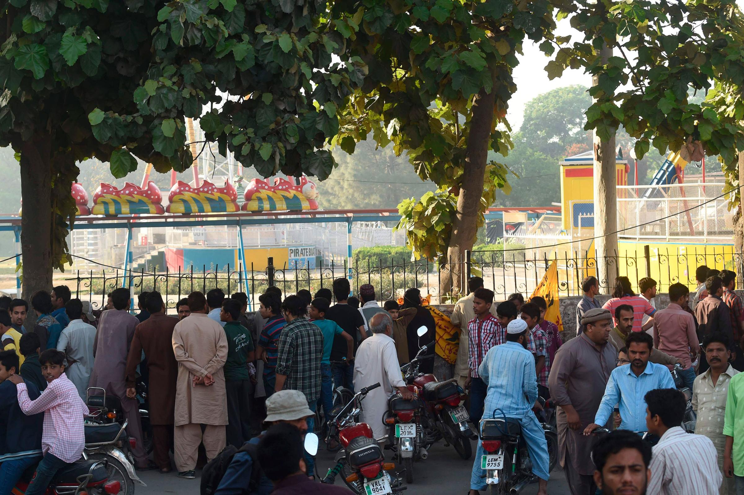 Local residents gather outside the cordoned-off site of the bombing at the park in Lahore, Pakistan, March 28, 2016.