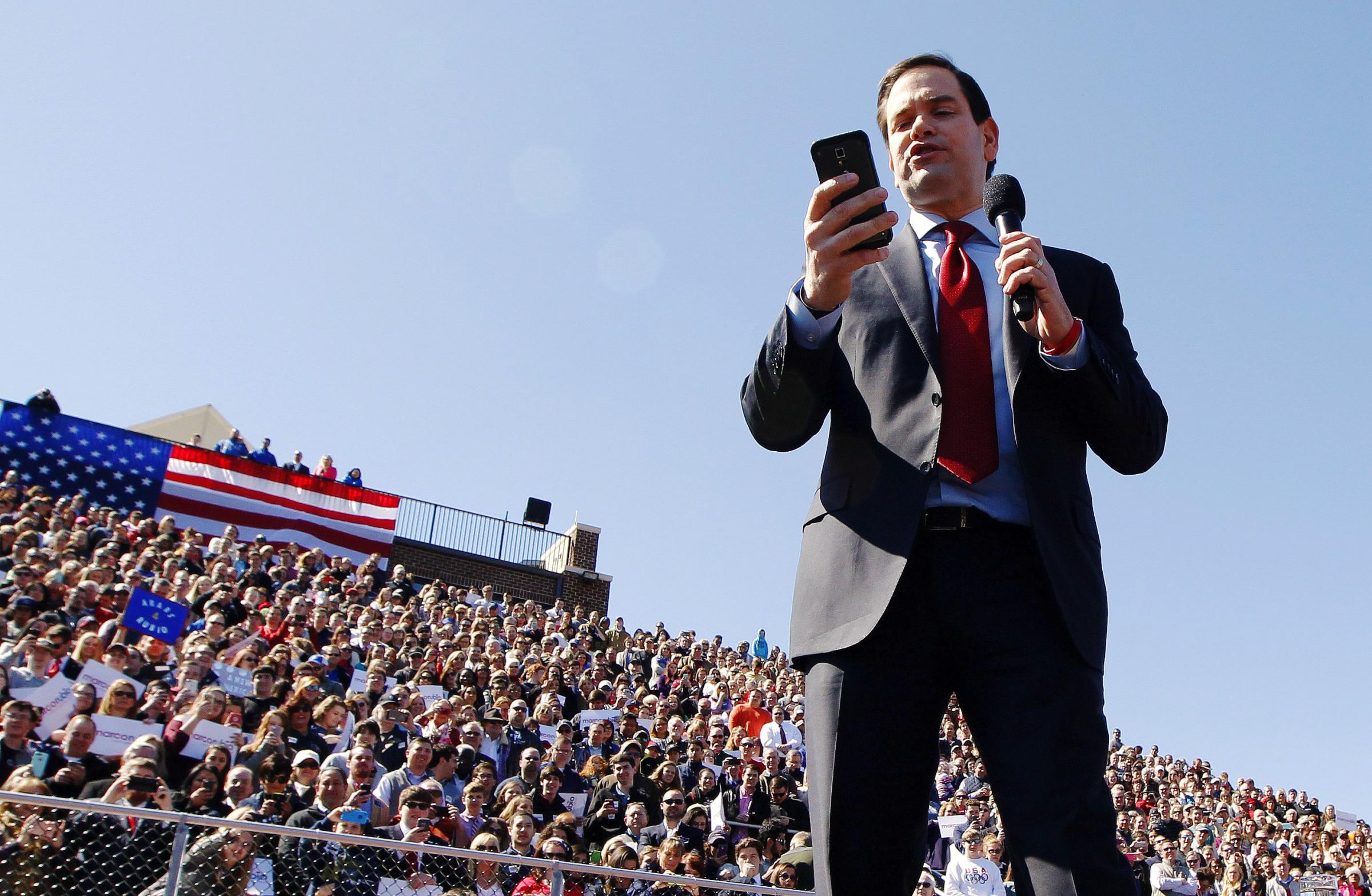 Republican presidential candidate, Florida Sen. Marco Rubio reads tweets from Donald Trump during a rally at Mount Paran Christian school in Kennesaw, Ga. on Feb. 27.