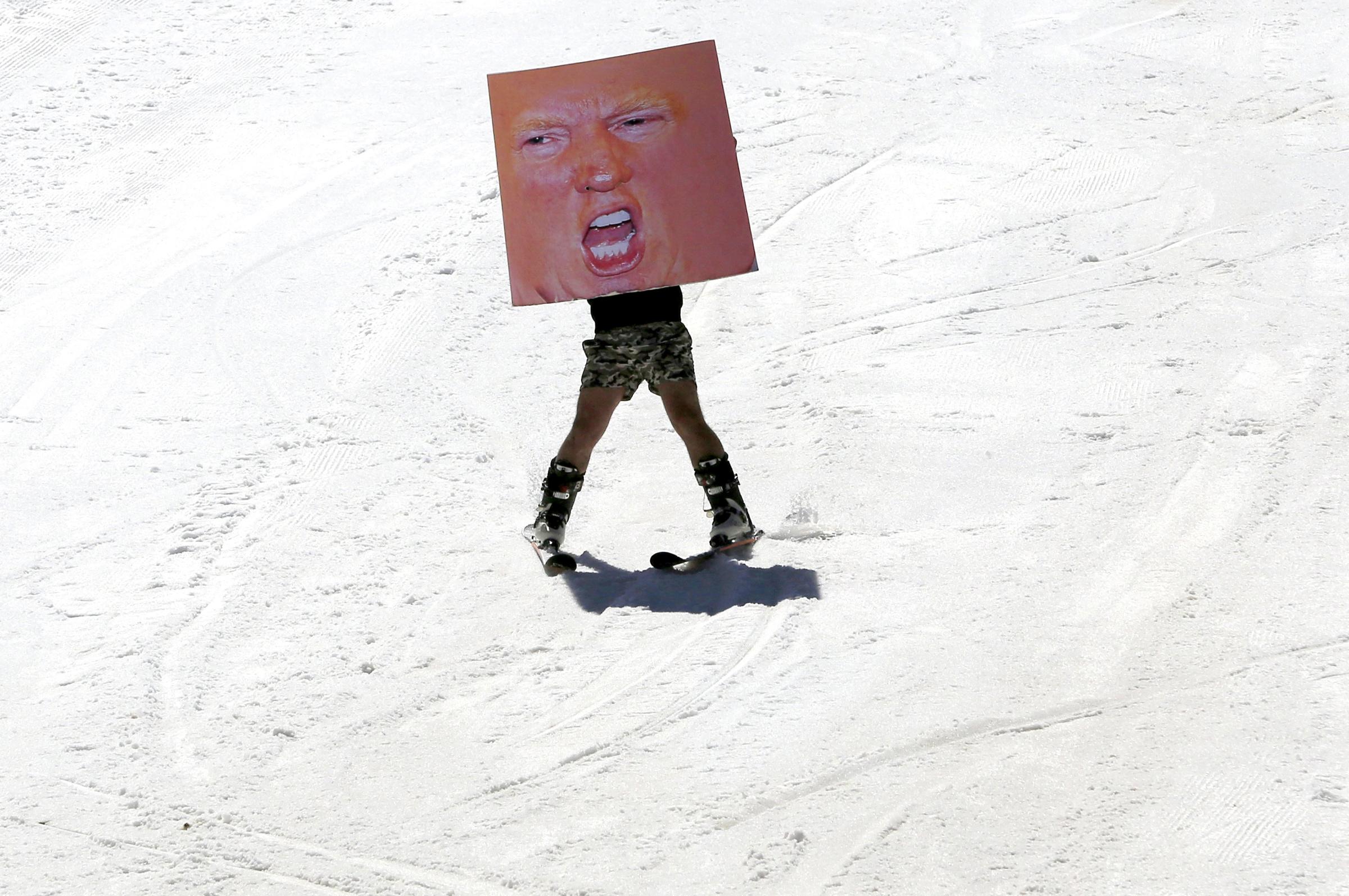 A man holds a poster depicting Donald Trump while participating in Red Bull Jump &amp; Freeze Lebanon at a ski resort in mount Lebanon on Feb. 28.