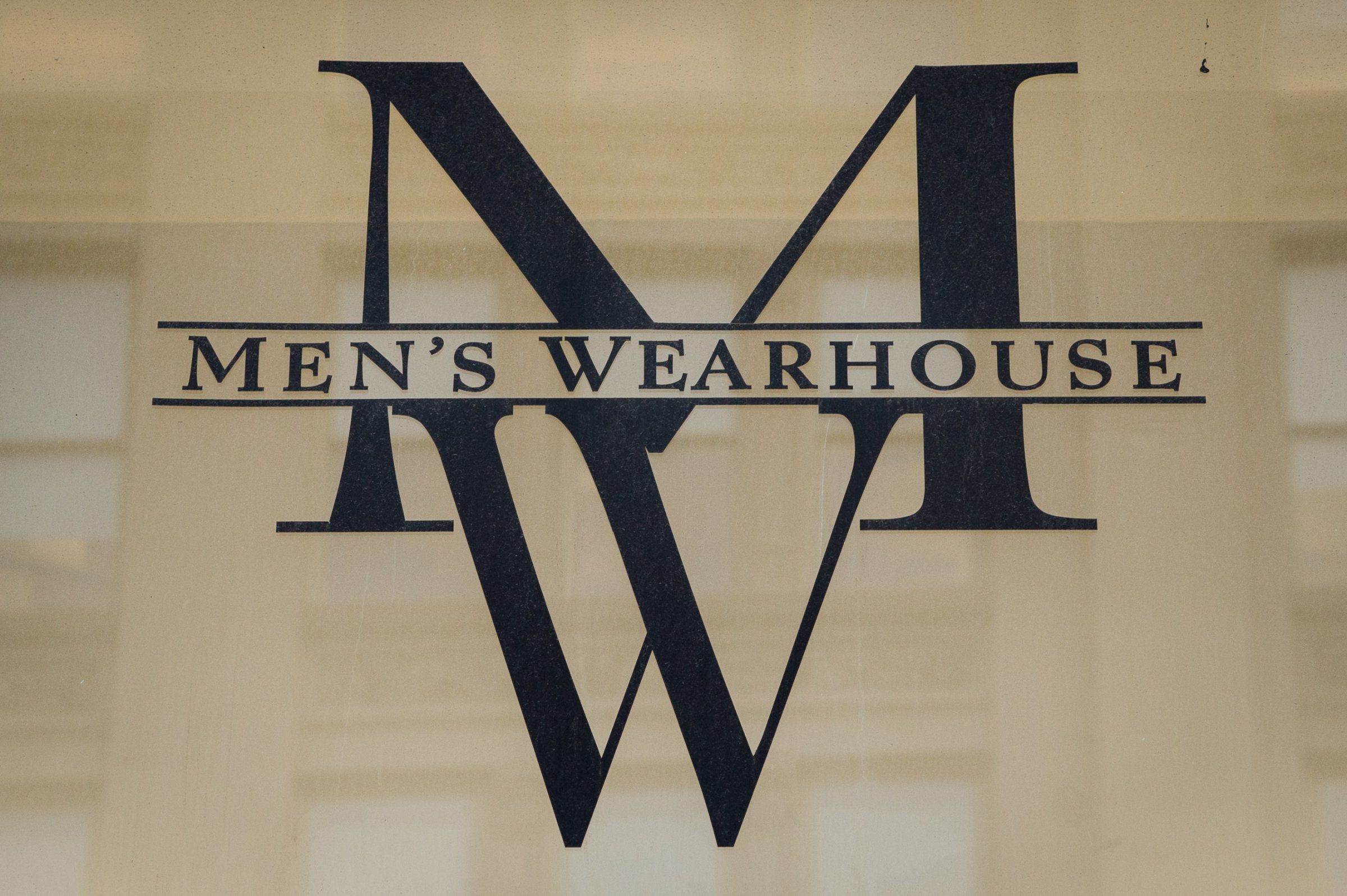 The Men's Wearhouse Inc. logo is displayed outside of a store on 6th Avenue in New York, U.S., on Monday, Dec. 2, 2013.