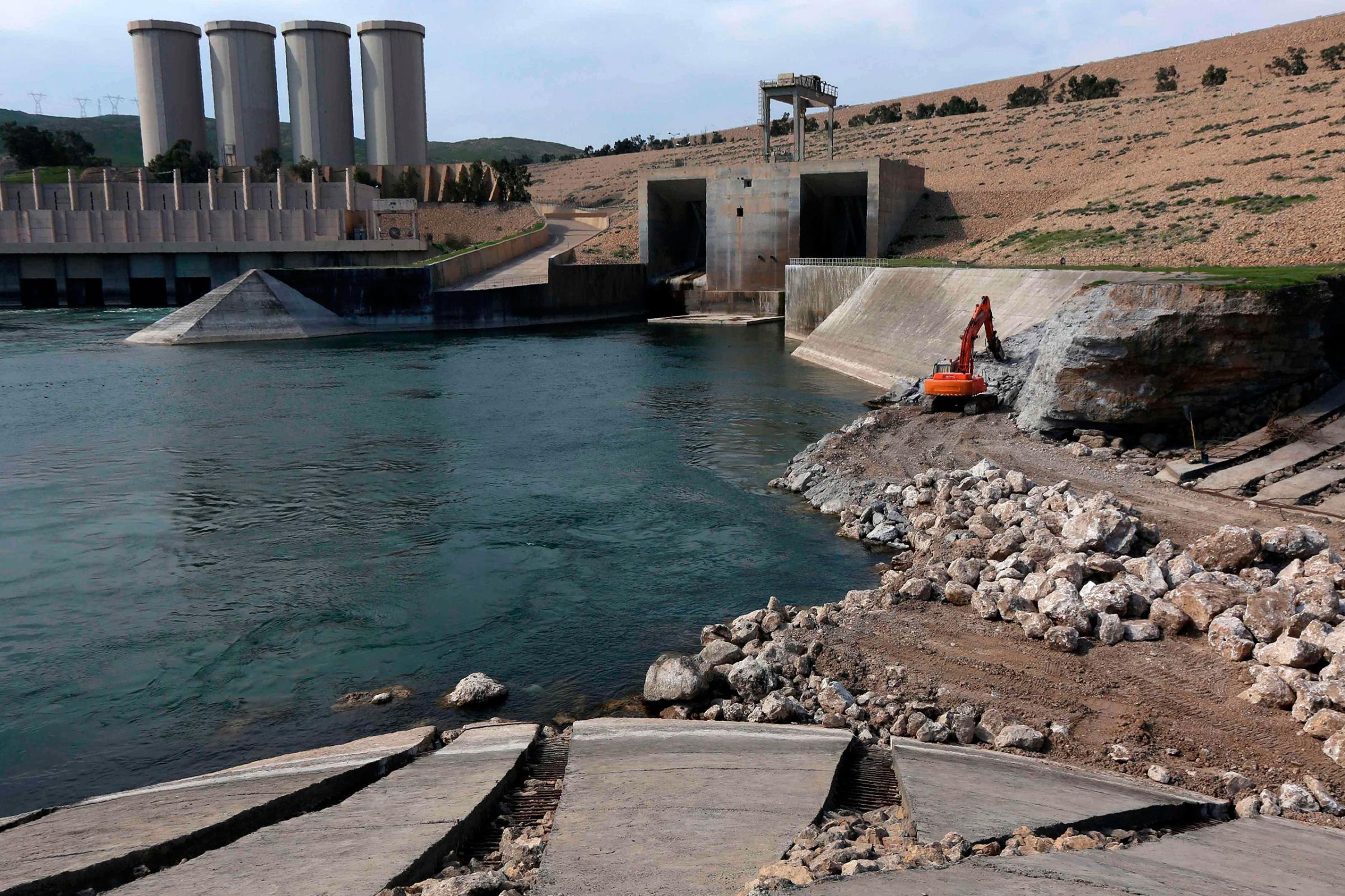 An employee operates an excavator as he works at strengthening the Mosul Dam on the Tigris River, around 50km north of Mosul, Iraq, March 3, 2016.