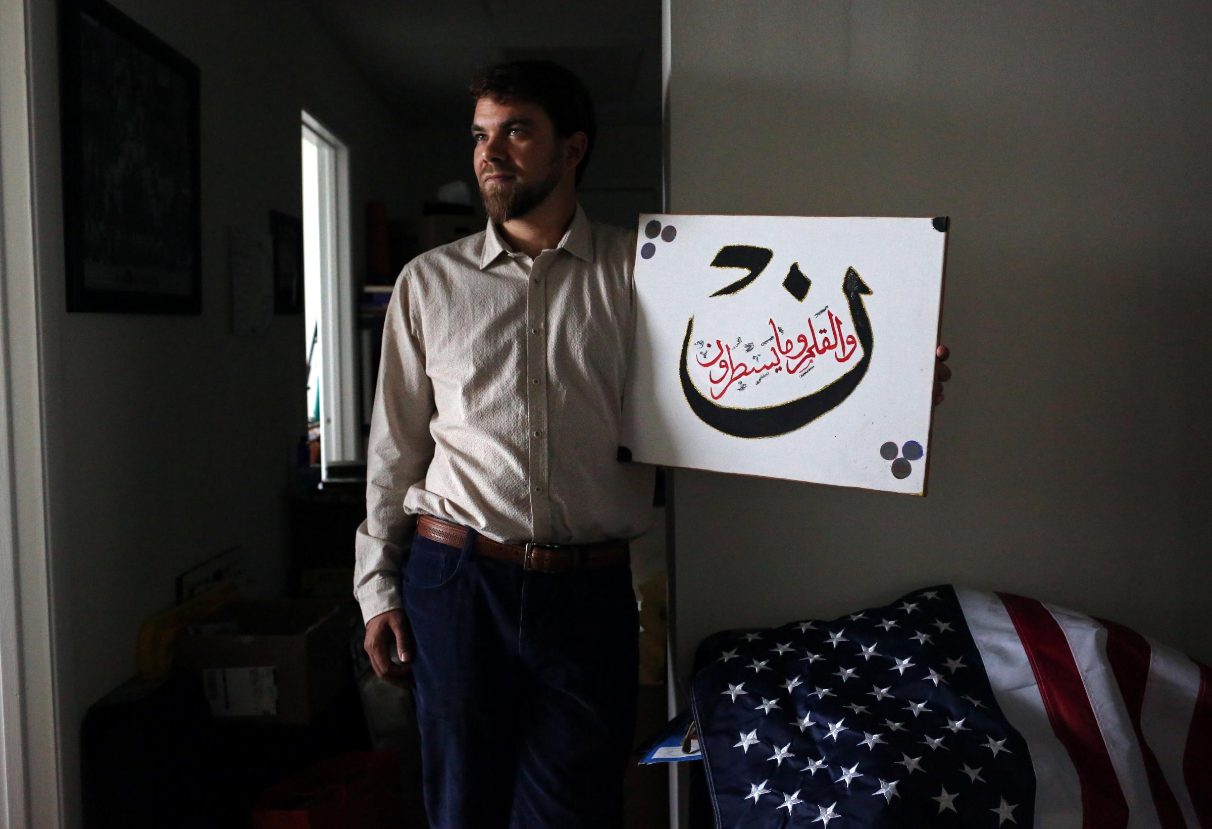 Adam Warshauer, 37, from Delray Beach, FL, whose father is Jewish and mother is a Christian, became a Sufi Muslim after being introduced to the faith by a man he met at 22. He is seen here posing for a portrait with a verse of the Koran, in a just-moved-into office space in Delray Beach, on March 12, 2016. He credits his background for being able to see connections between the three religions, and plans to start a YouTube show directly addressed to U.S. Presidential candidate Donald Trump (R-NY,) with the aim of creating peace between the Israel and Arab nations. It would feature a hand puppet called Uncle Musa - a relative to Moses, a prophet who appears in the Torah, Bible and Koran.Politically, he says he identifies most as an Independent: I believe in protecting the environment, and Republicans dont, which is why I am not Republican. Warshauer plans to support Trump, however, especially if he wins Tuesdays primary elections and goes on to become the Republican nominee for president. Warshauer says he does not believe Trump wants to ban Muslims from entering the country because of a dislike for them, but because he wants to solve terrorism. Most are outraged at Trump saying he wants to ban Muslims from entering America, but I support that as a Muslim person, because we have to stop what is happening and work with other Muslim countries to stop terrorism. If you stop Muslims from entering the country, it forces everyone to look at the problem. He adds that Isis killings are ruining the face of Islam. Who wants to become Muslim when it is associated with terrorism?People pull stuff they want to go Oh, my God! about, but come on, forget about that and just focus on what's real, which Warshauer says is Trumps job creation capability and his focus on stopping the drug epidemic in America, heroin specifically. He adds that Trump is more approachable than other Republican candidates like Ted Cruz (R-TX) and Marco Rub