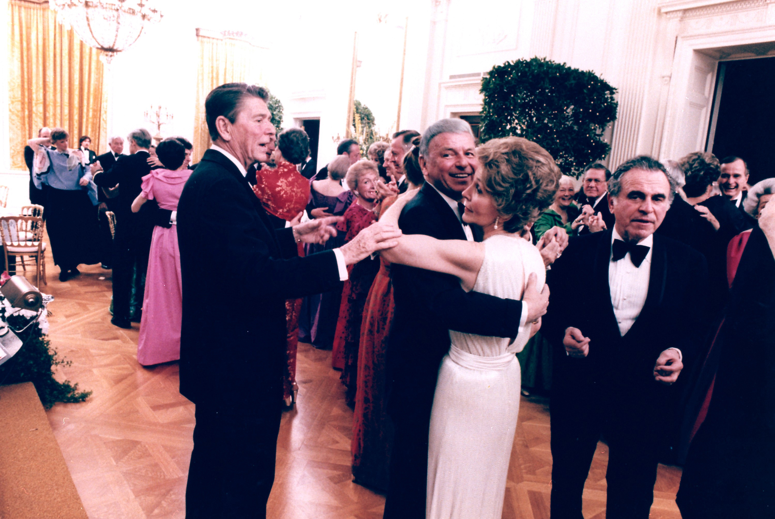 Ronald Reagan cuts in on singer Frank Sinatra, dancing with former first lady Nancy Reagan during a party in the East Room of the White House on Feb. 6, 1981.