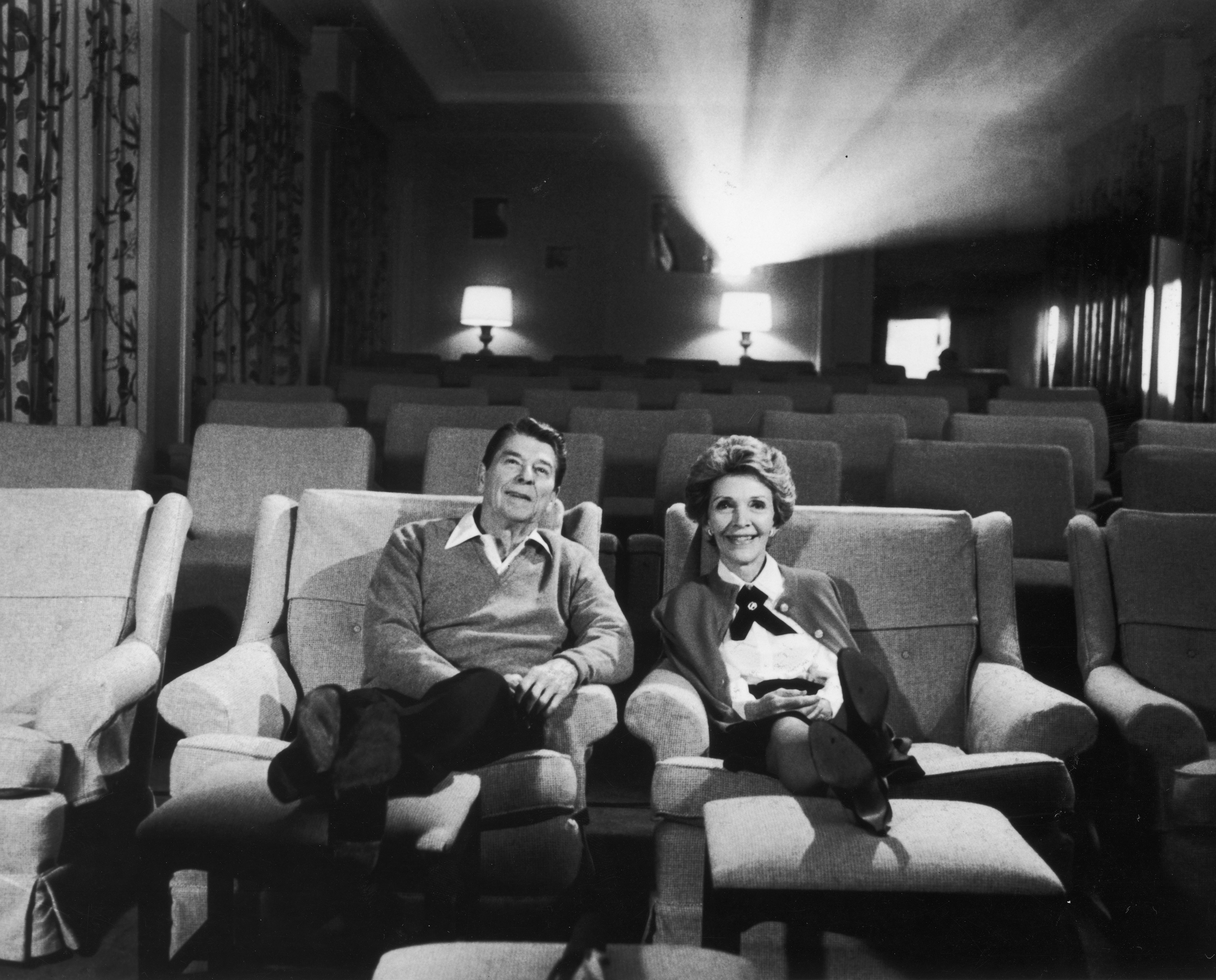 President Ronald Reagan and wife Nancy Reagan sit together in their screening room, circa the 1980s.